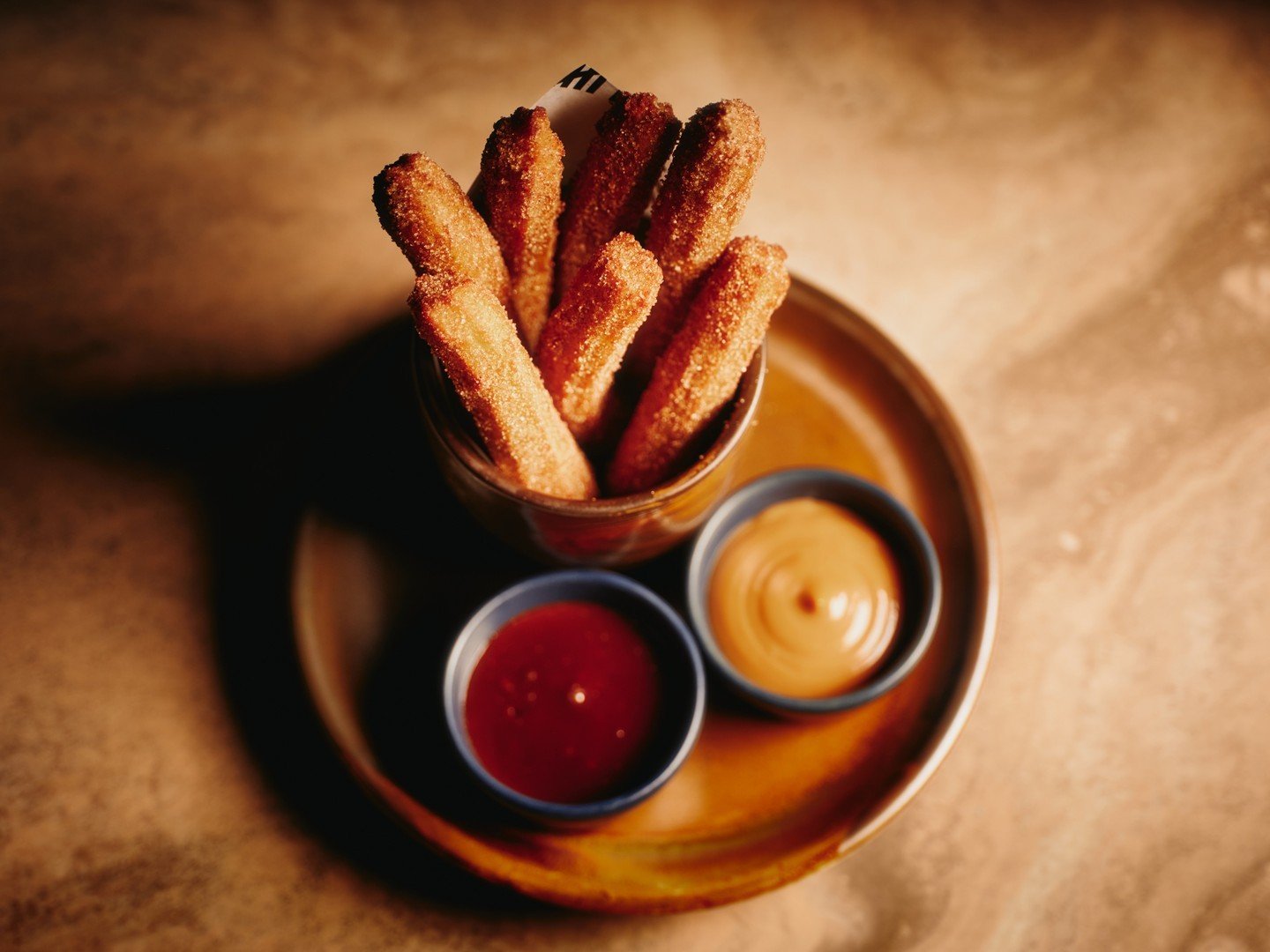 Churros De La Calle season? El Tigre's cinnamon-sugar-coated goodness, are finger-licking heaven. Tigre's served them with Chocolate Salsa and his homemade Dulce de Leche Salsa. ⁠
⁠
double yum. Book your spot #NineLives