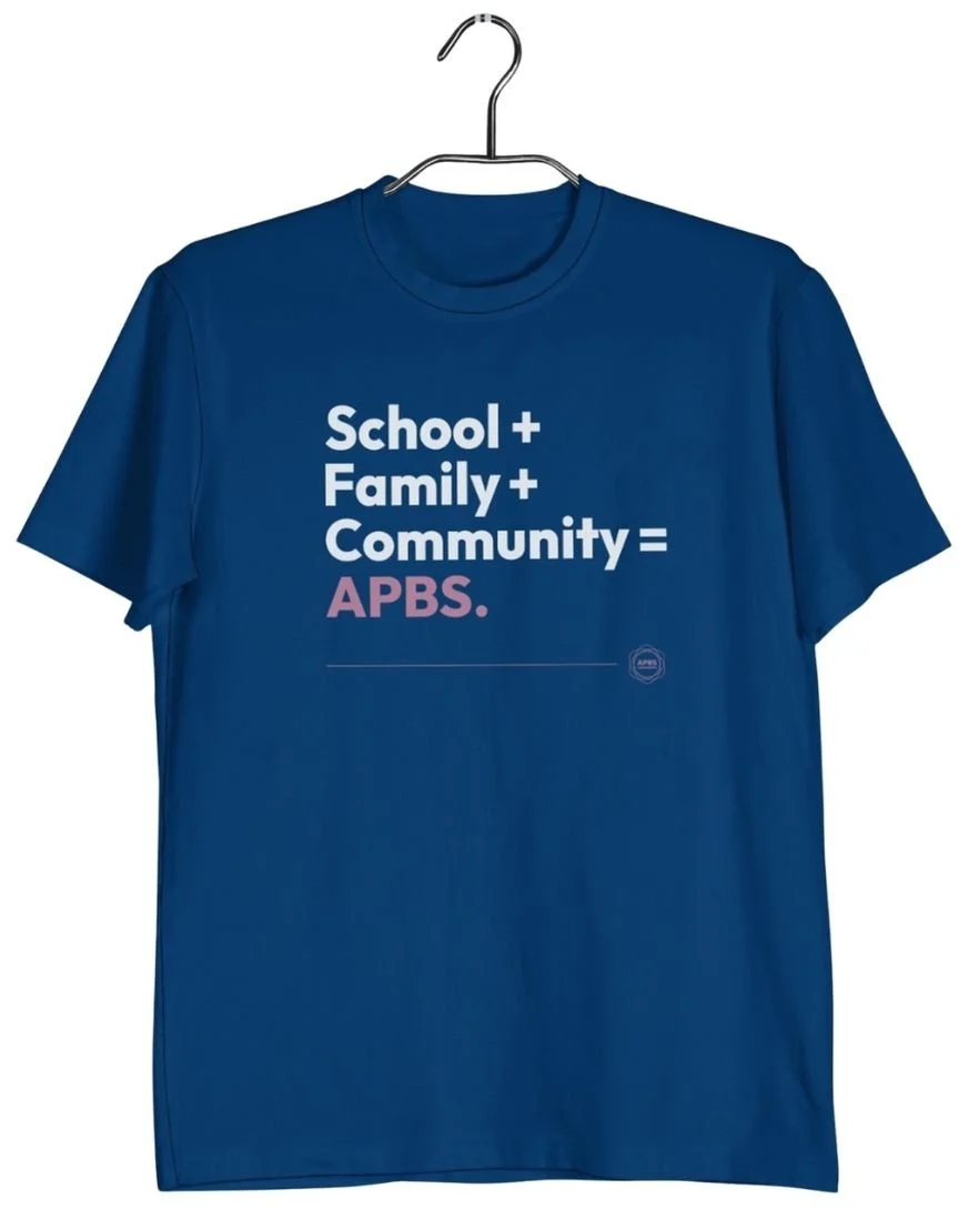Mockup of a dark blue t-shirt with the APBS conference logo and text reading School + Family + Community = APBS in white and pink.