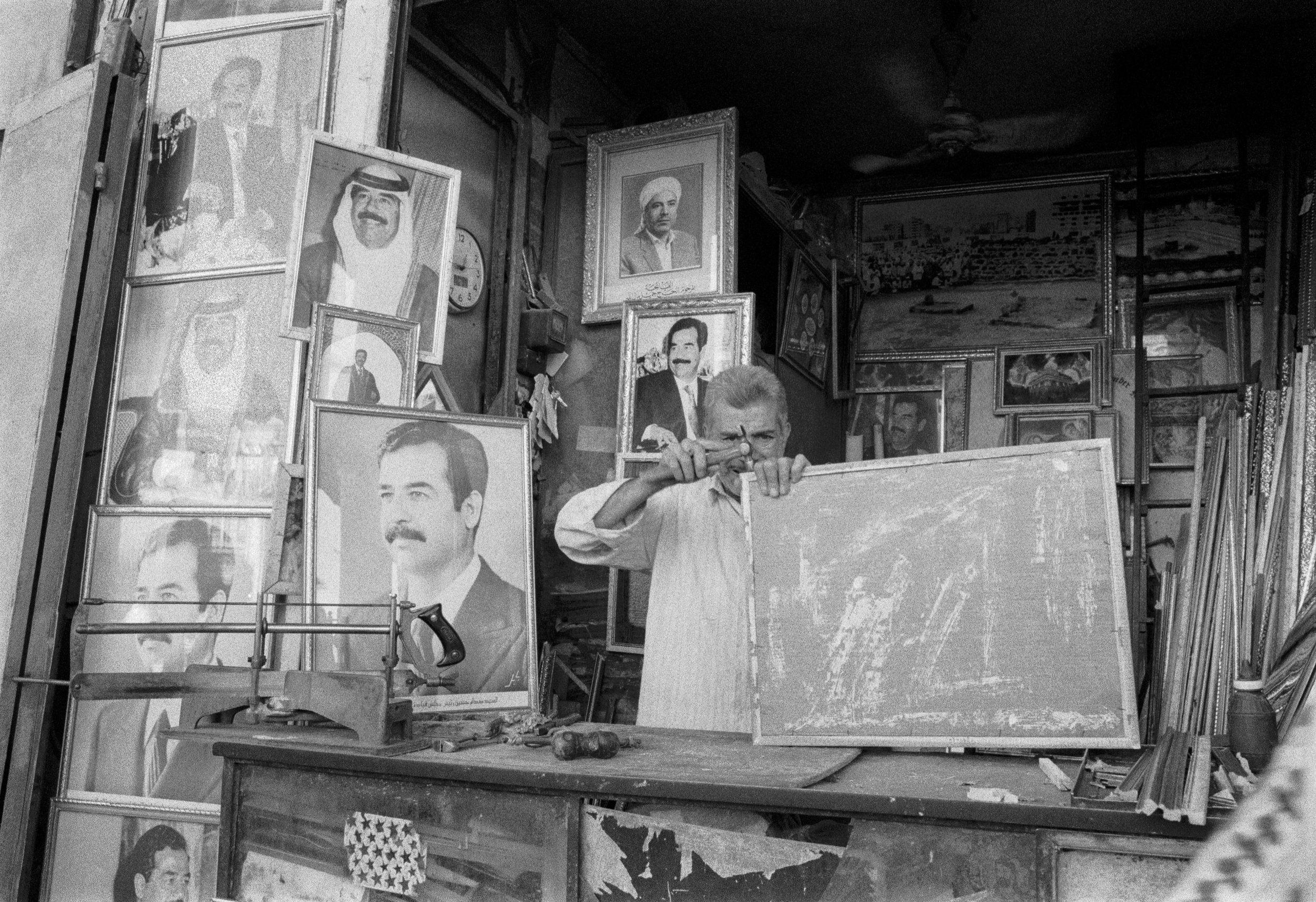  At the Safah Afir copper market in Baghdad, Iraq a man makes frames mostly for images of Saddam Hussein.   