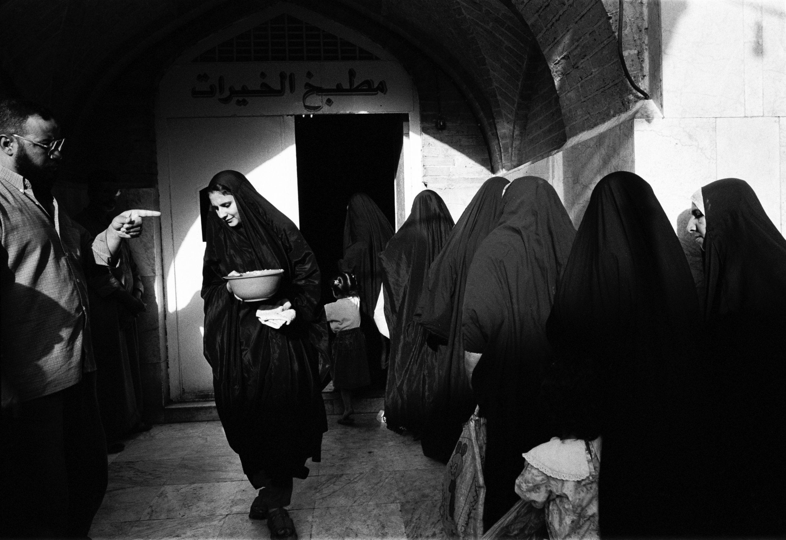  At the Al-Khazani Mosque in Baghdad, Iraq women wait for a free meal. 