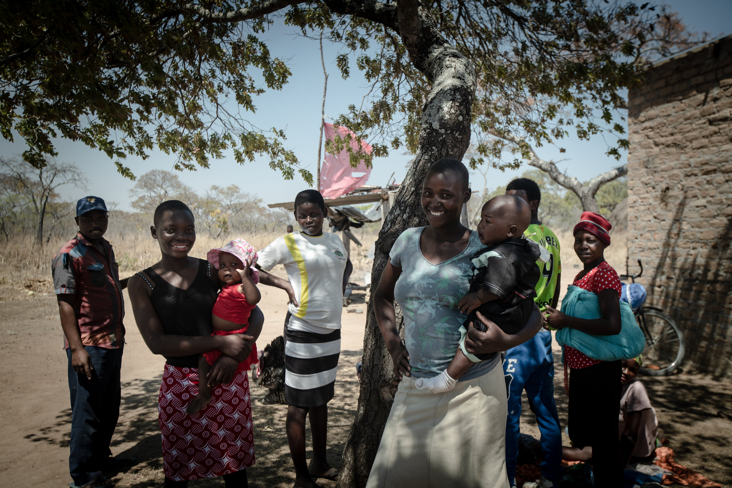  Beknown and Mediator with their children and relatives in front of their family house in Chisungo, Zimbabwe, 2019 