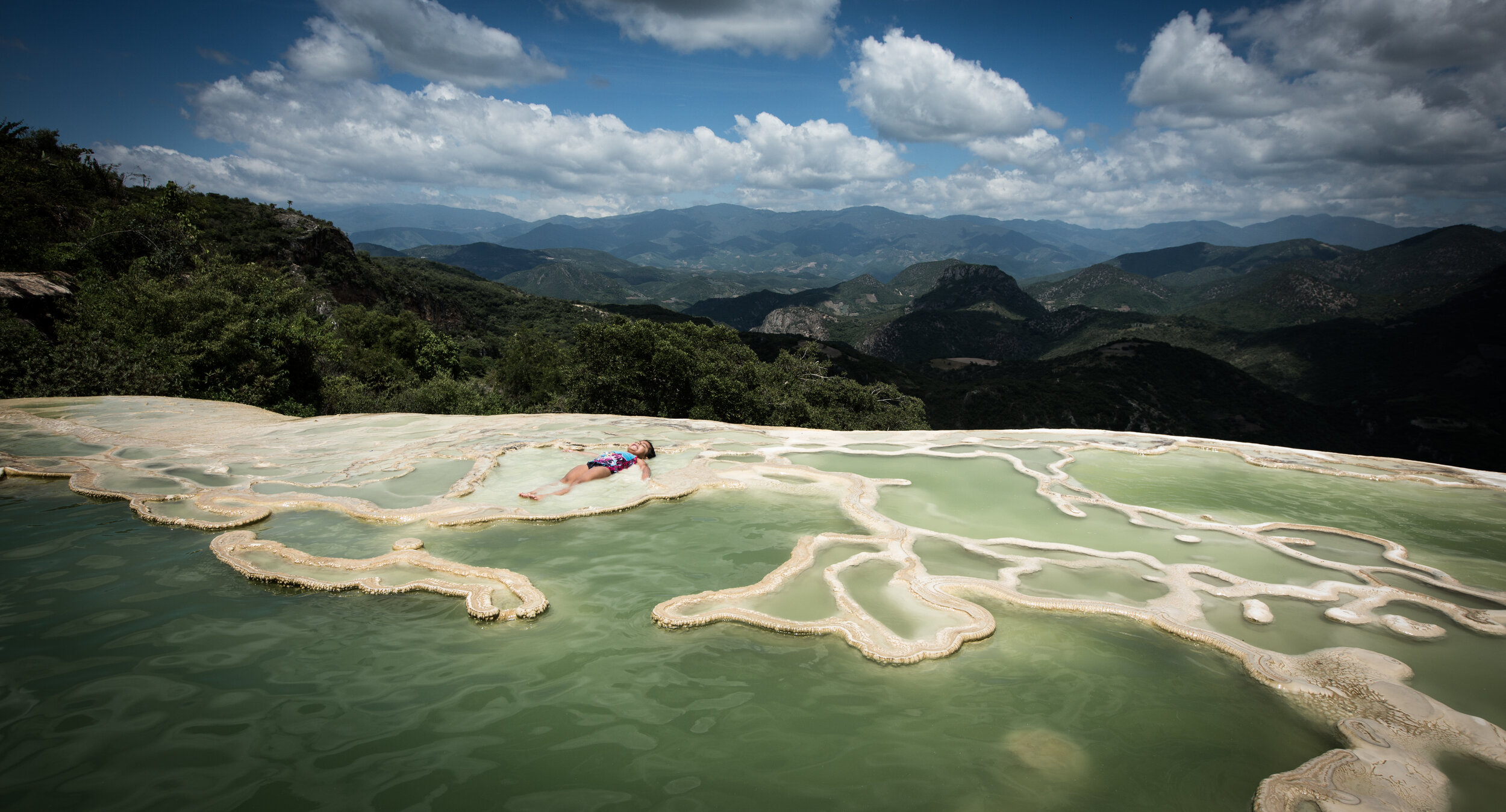  a young girl bathing in the mineral-rich water of Hierve El Agua, Oaxaca, Mexico, August 2017 