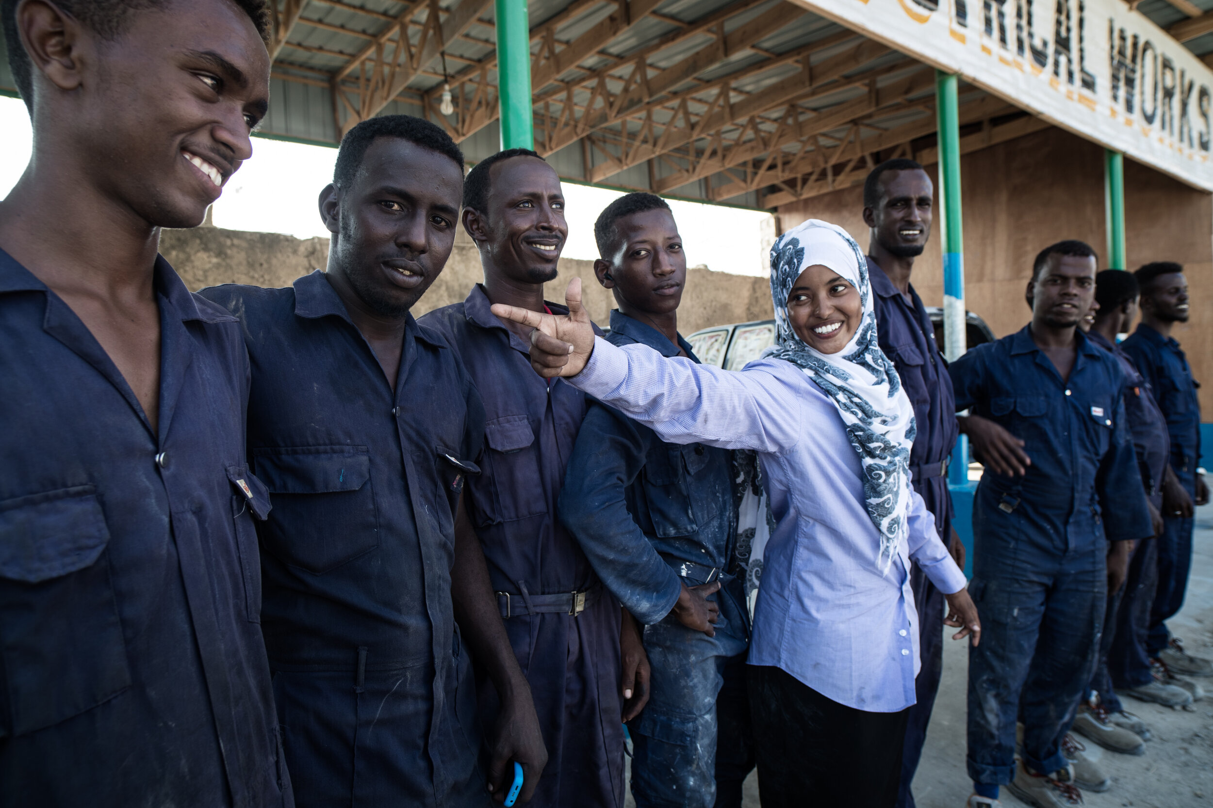  18 years old Nasra Haji Hussein Ibrahim, Somalia’s first woman mechanic, posing with the team of mechanics. Mogadishu, 2017 