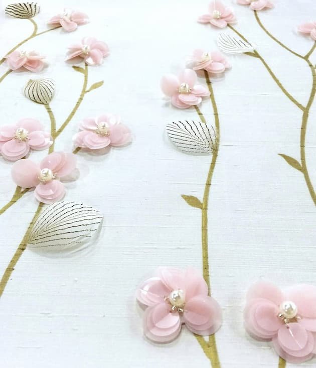 close-up-white-baby-blossoms-embroidered-wallpaper-light-pink-flowers-dark-green-leaves-white-pearls.jpg