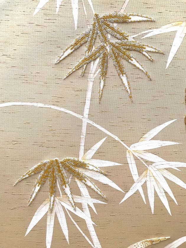  Designer wallpaper showcasing hand-painted white bamboo leaves on a beige background, a Chinoiserie masterpiece for luxurious interiors. 