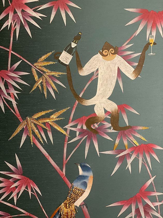  Hand-painted bamboo jungle wallpaper featuring mischievous monkeys and blue birds toasting to joie de vivre, a designer choice for joyful luxury interiors. 