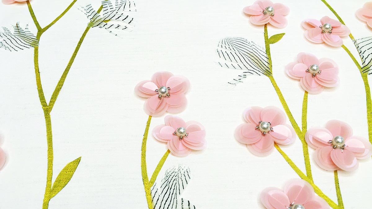  Designer Baby Blossoms Embroidered Wallpaper with a close-up of delicate light pink flowers, dark green leaves, and white pearls, enhancing luxury interior spaces with serene elegance. 