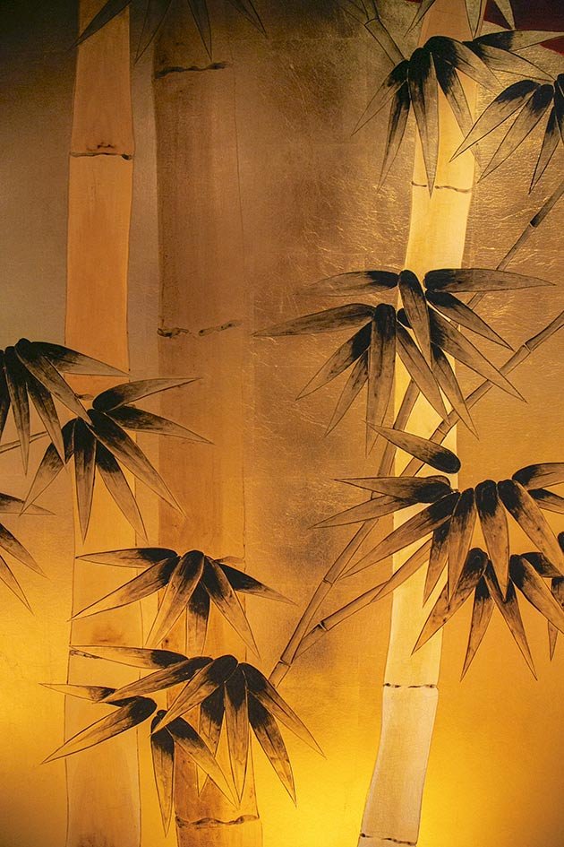 Designer Bamboo Haven Chinoiserie Hand-Painted Wallpaper: Serene red bamboo trees mural in a minimalist room, showcasing exquisite oriental art for luxury living spaces. 