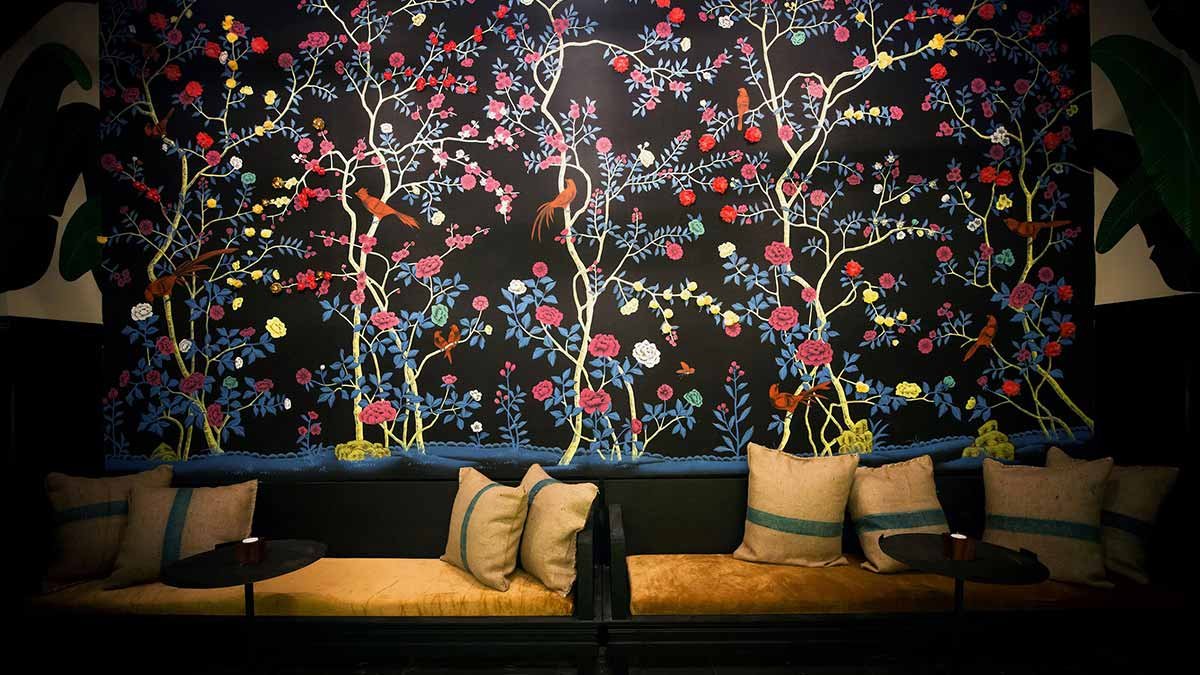  Psychedelic Forest hand-painted wallpaper showcasing colorful trees, flowers, and birds on a black wall, ideal for adding a vibrant touch to luxury interior designs. 