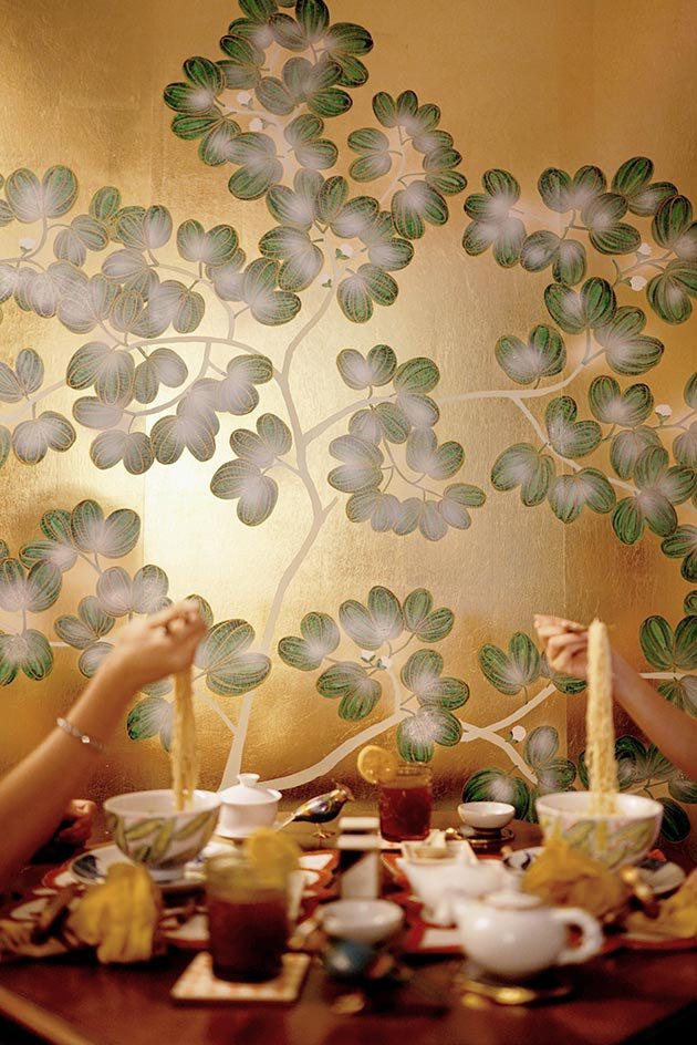  Hand-painted Moonlight Forest wallpaper in a dining setting, where two people enjoy noodles against a serene forest mural backdrop, enhancing the space with a dreamy and enchanting ambiance. 