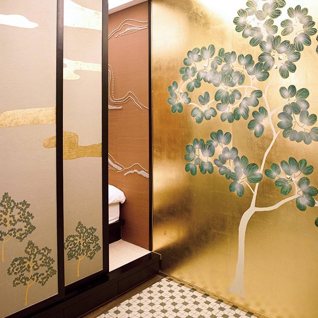  Enchanting Moonlit Forest hand-painted wallpaper with a gold sky backdrop featuring luminous trees, bushes, and flowers, ideal for creating a serene and dreamy wall section in upscale interiors. 