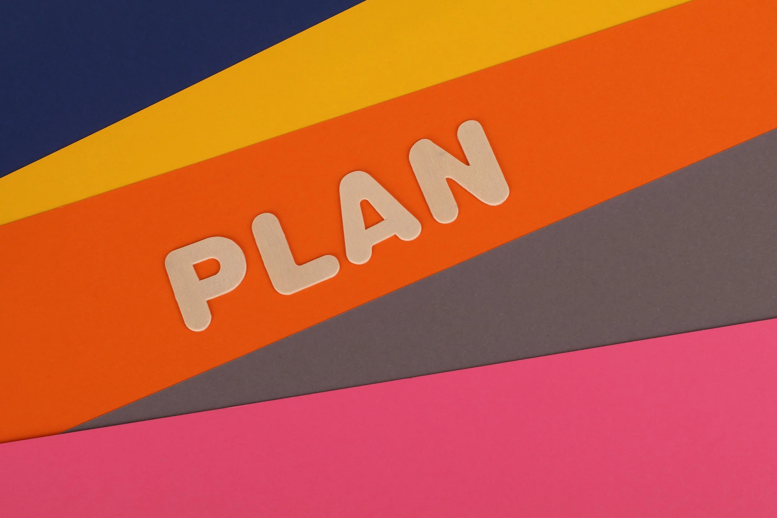 A colorful stack of papers with the word "plan" on top.