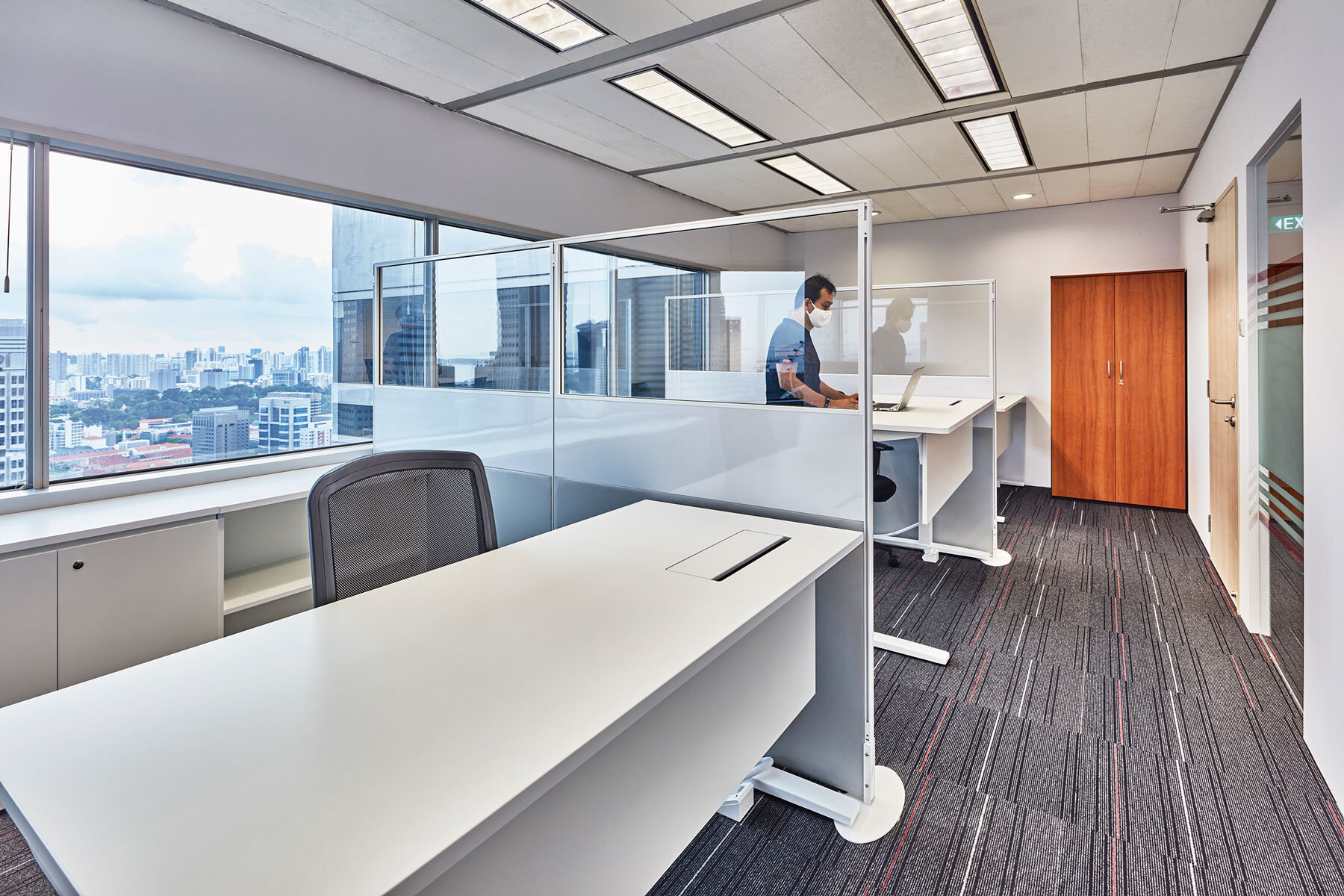  Generous clear dividers serve as physical distancing shields between adjustable-height desks 