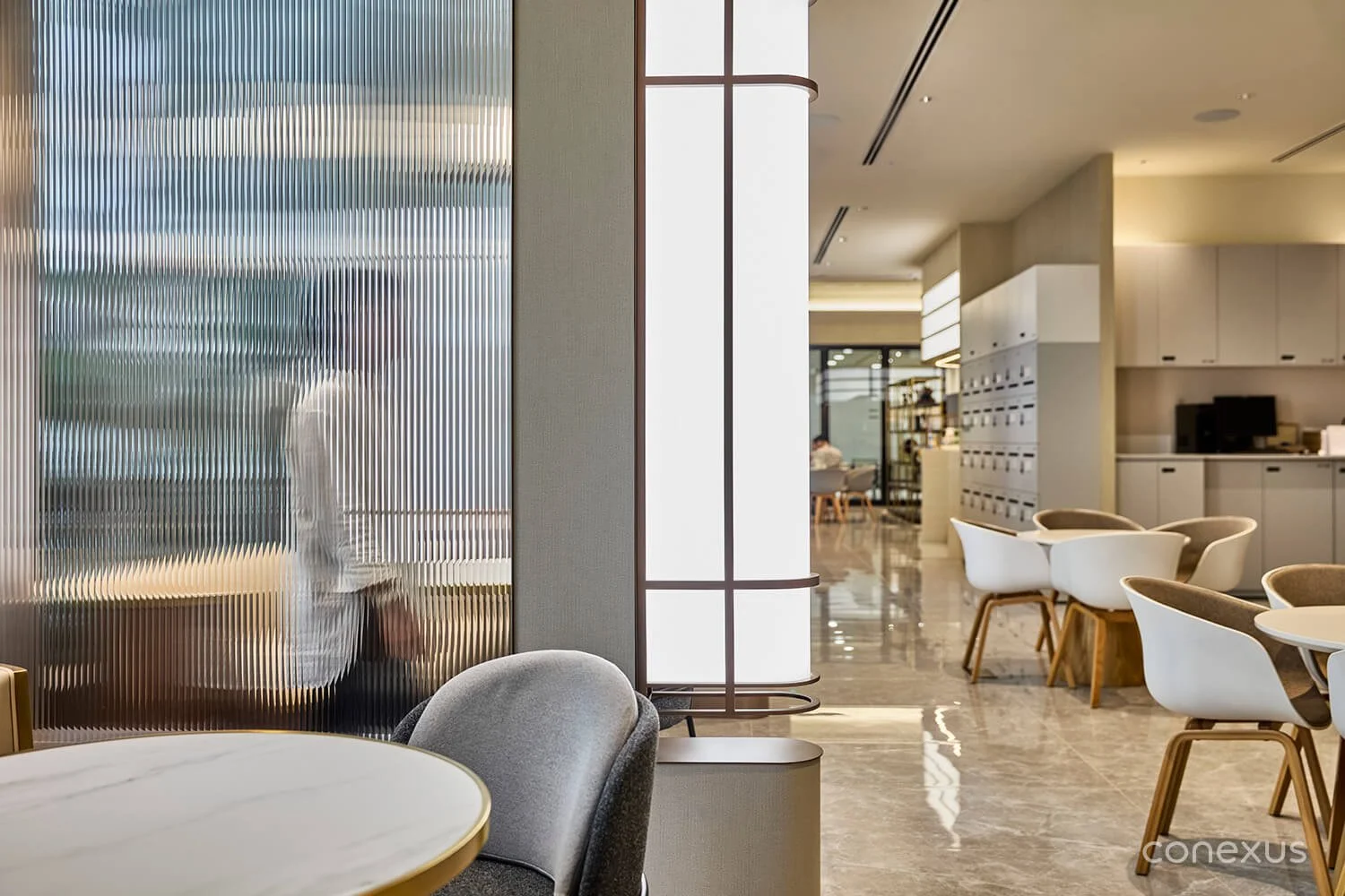  Fluted glass panels provide discreet privacy for sensitive client consultations while maintaining the open and hospitable atmosphere of the workspace. 