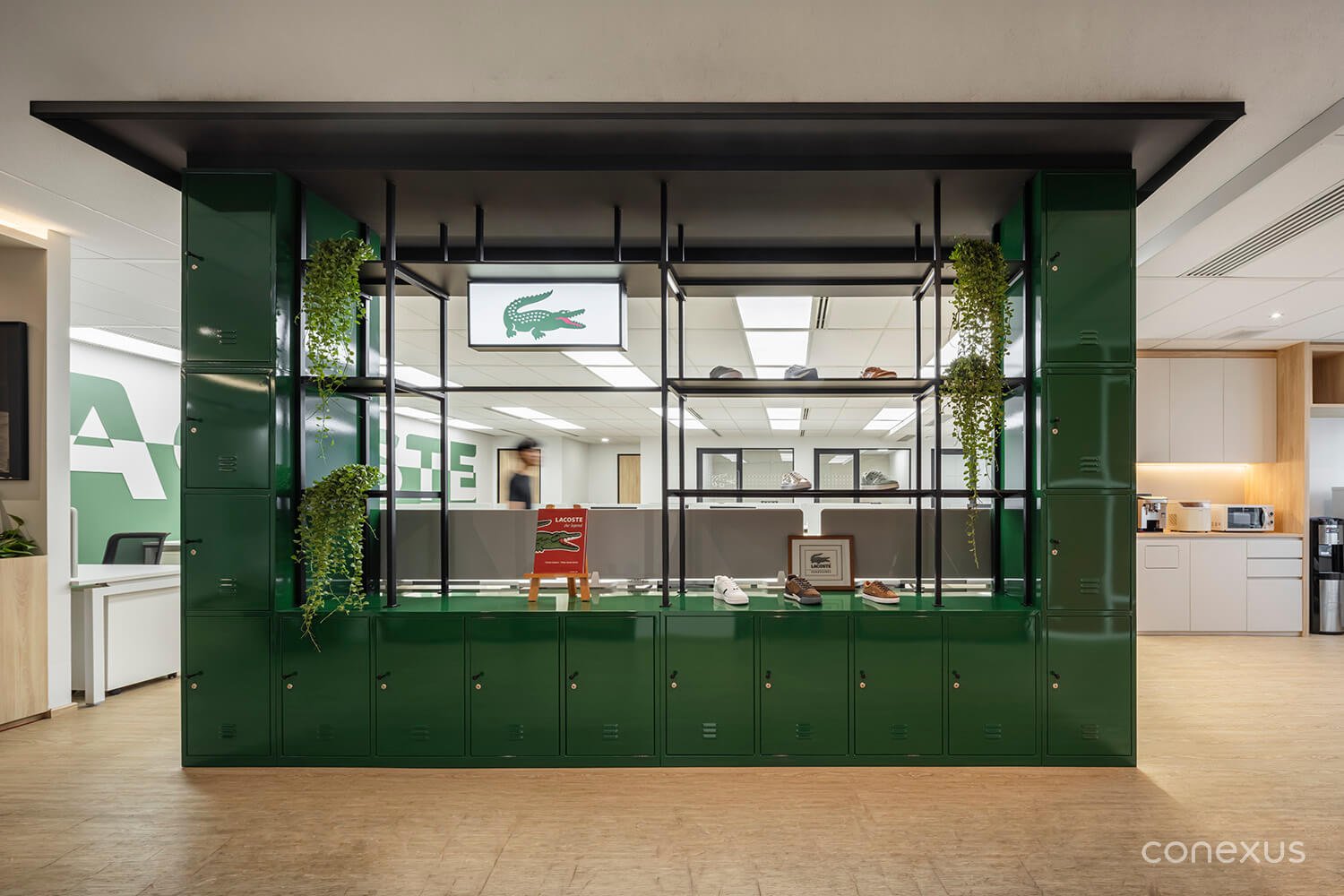  The green locker wall consolidates storage, display, and spatial separation — maximising function within a limited footprint. &nbsp;  