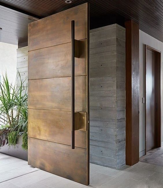 Bronze stripped pivot door . A contemporary pivot entrance made in bronze with an antique cloudyness effect on the bronze skin . The door also incorporates a long heighted bronze rod handle with knurning effect at its ends .
.
.
.
#inspiration . Desi