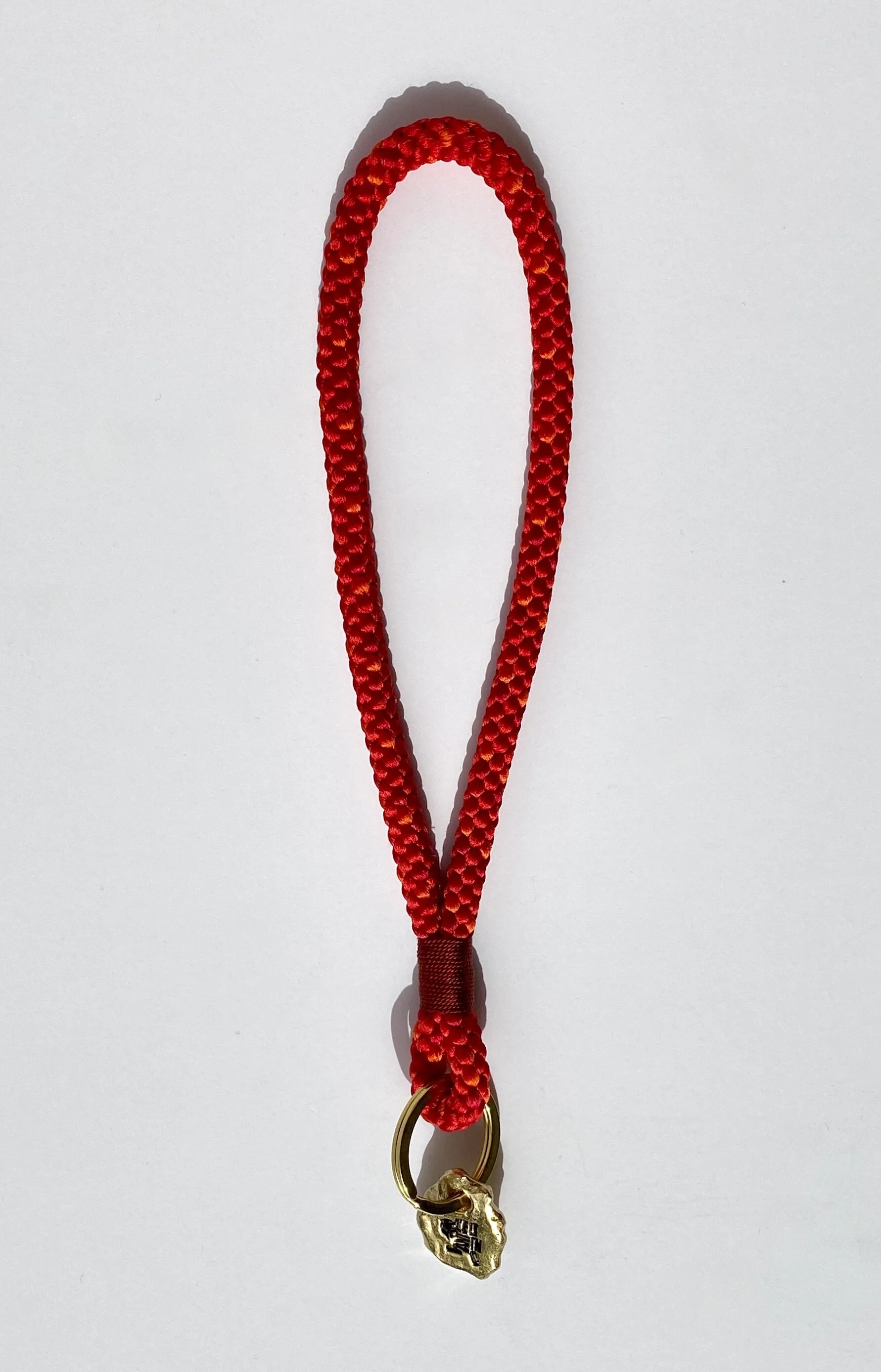 Short Key Strap made out of silk, in the colors bright red and orange, with a red finish