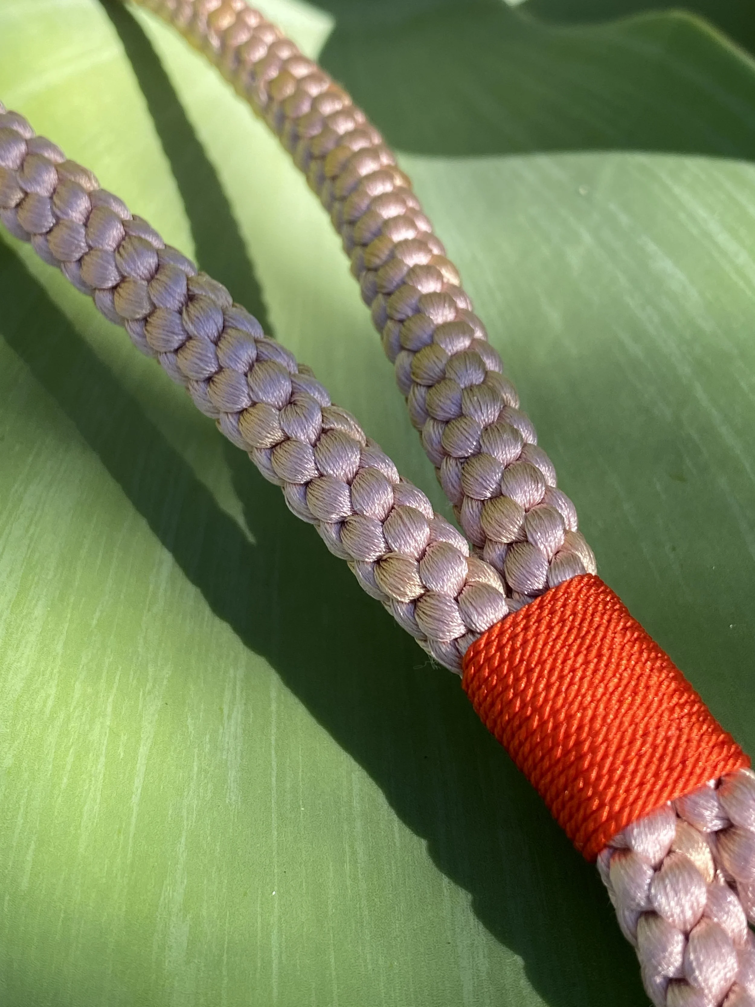 Long Key Strap made out of silk, in the color rose, with a bright orange finish