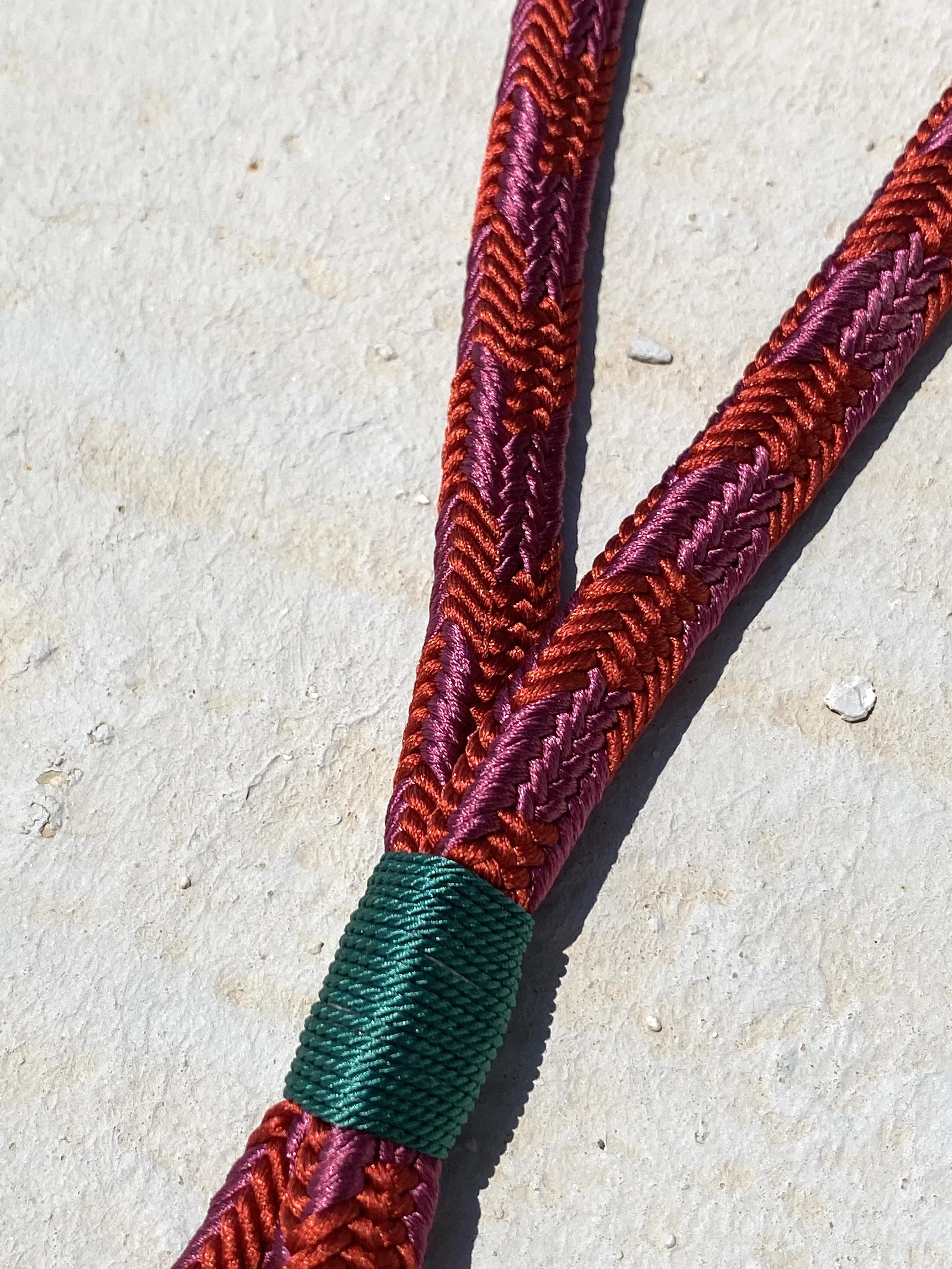 Short Key Strap made out of silk, in the colors red and bordeaux, with a green finish