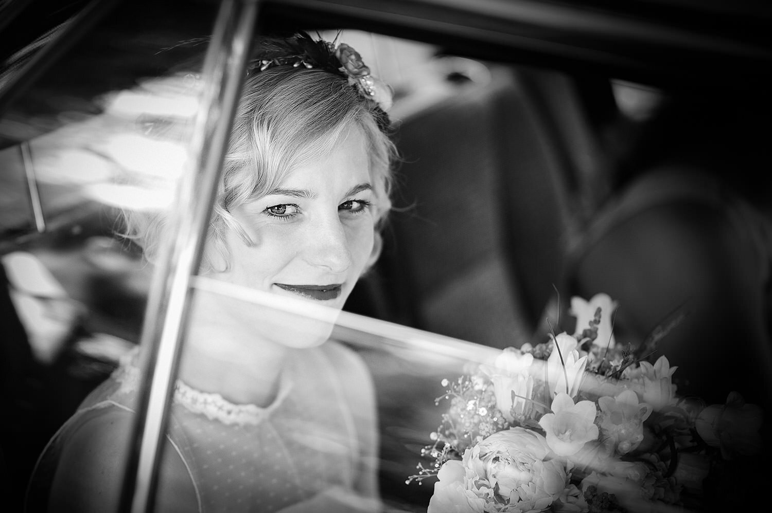 Braut schaut aus dem Fenster des Hochzeitsautos