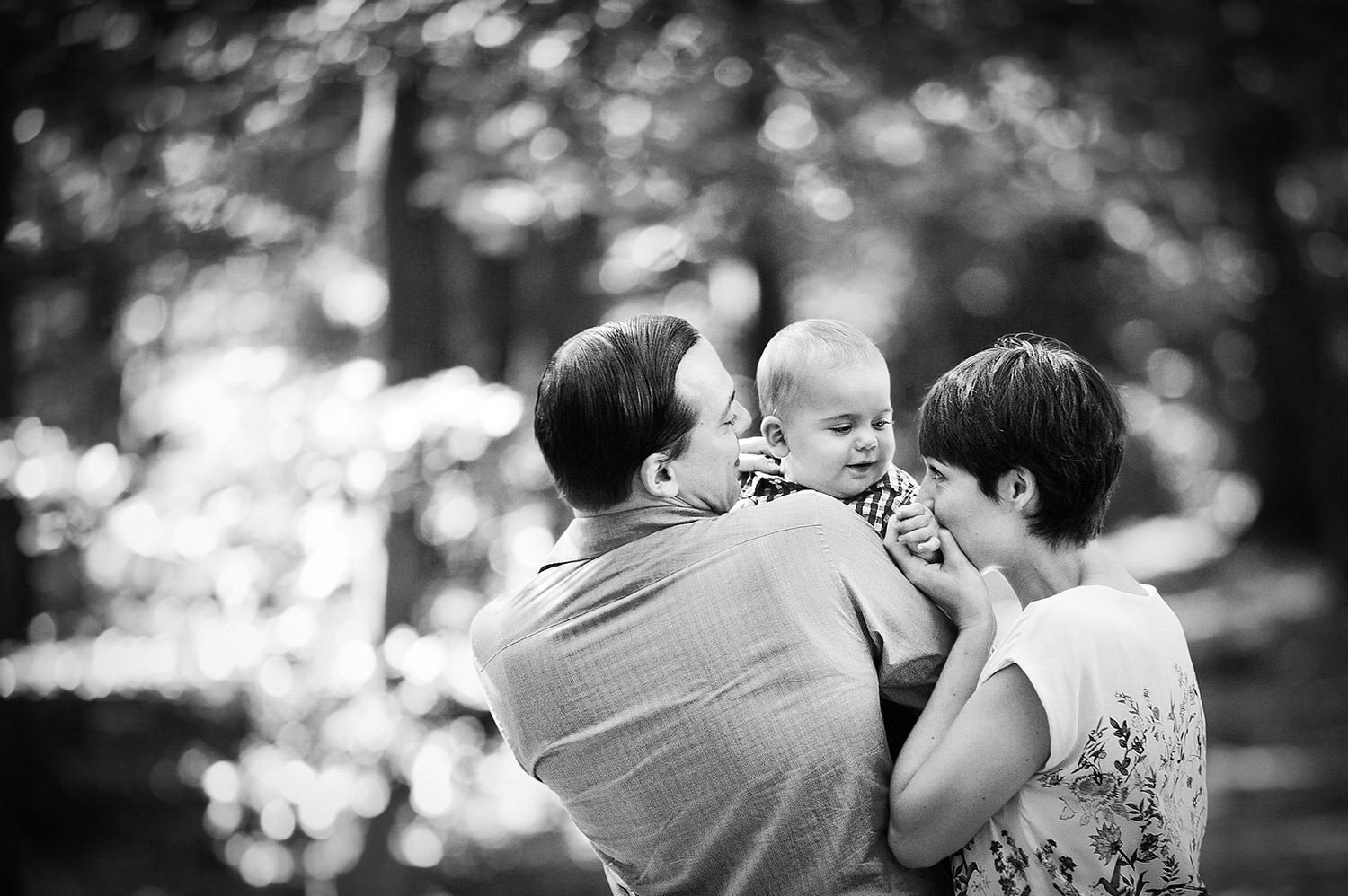 Mutter und Vater lächeln das Baby an