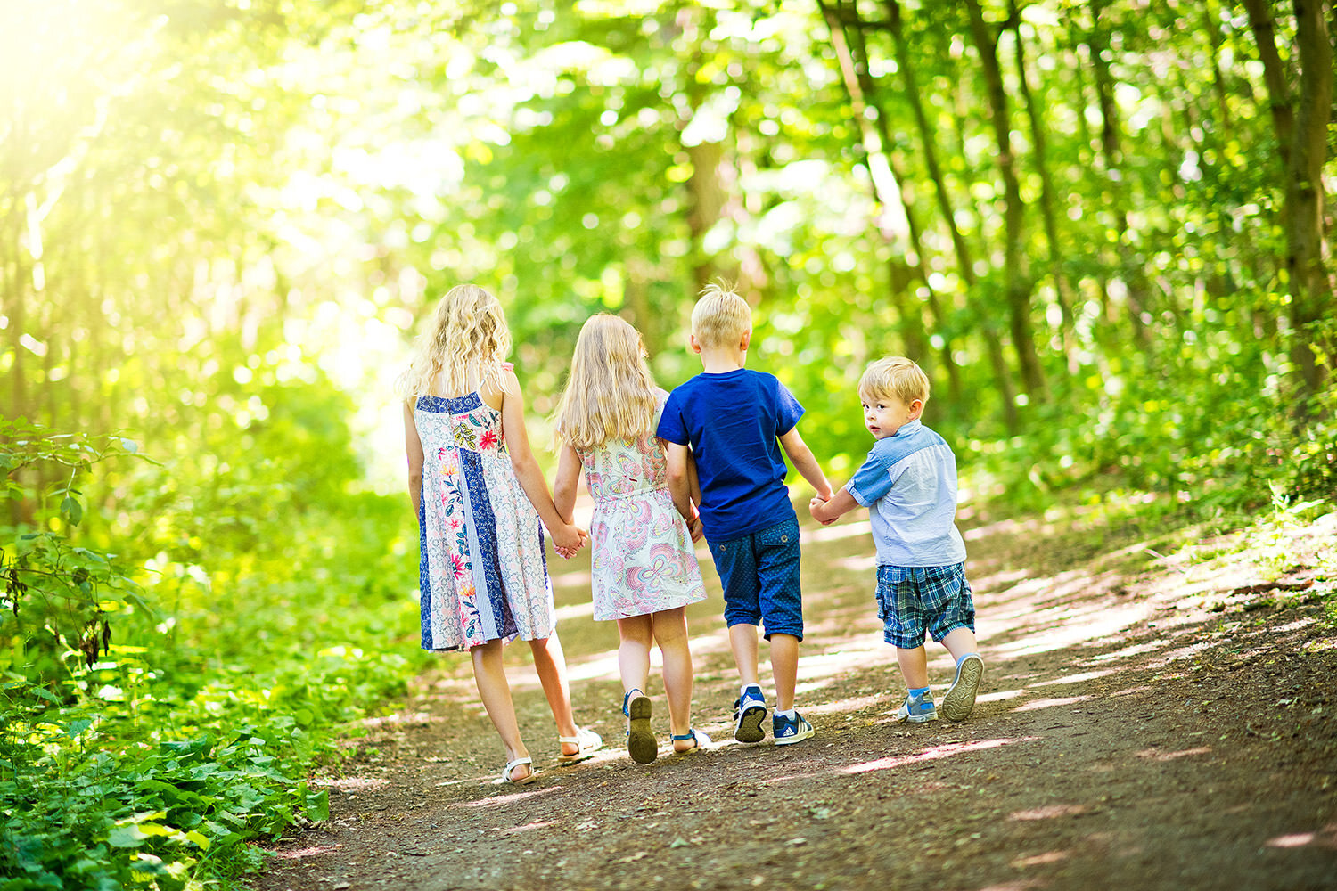 Vier Kinder spazieren durch den Wald