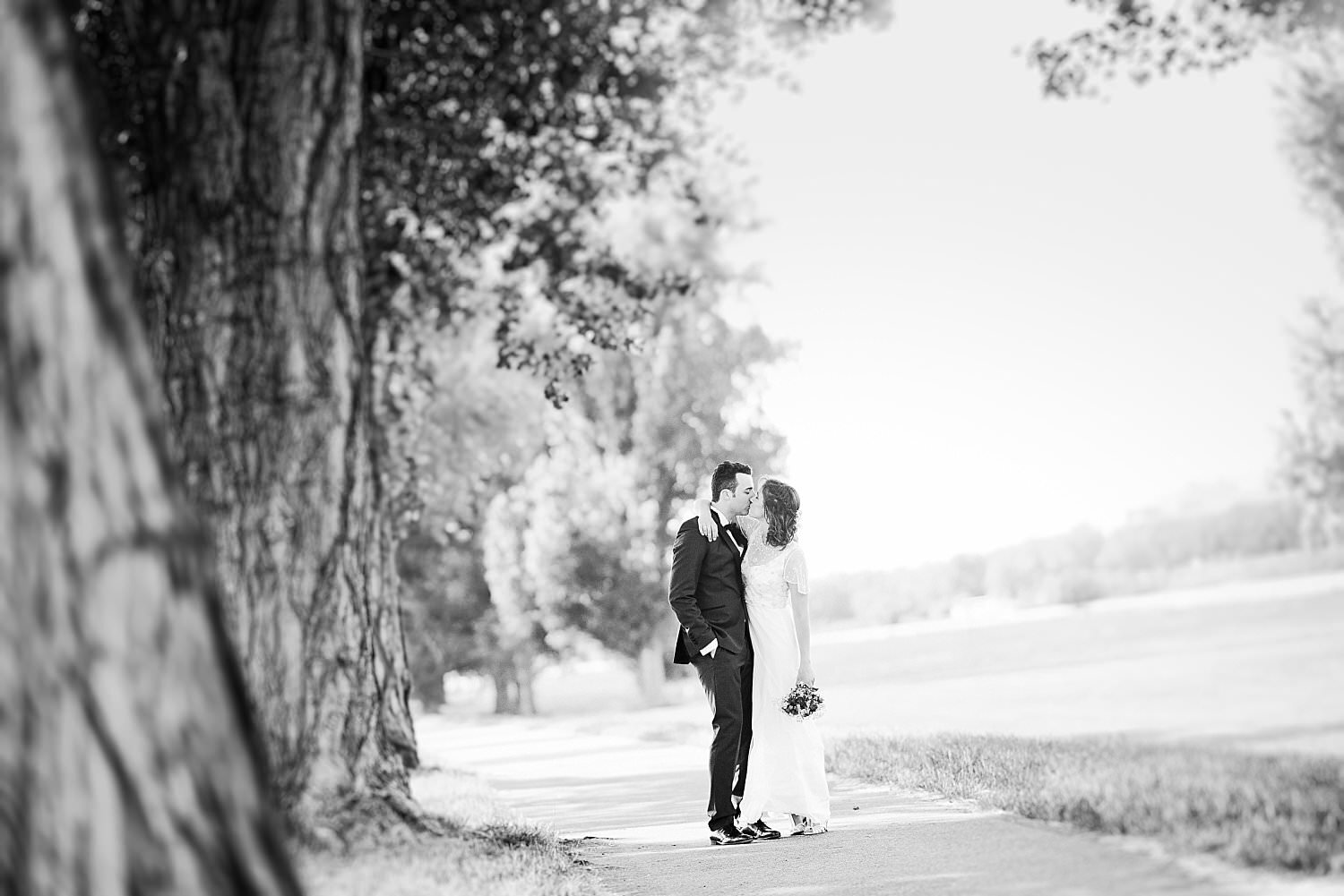 Braut und Bräutigam küssen sich in einem Feld
