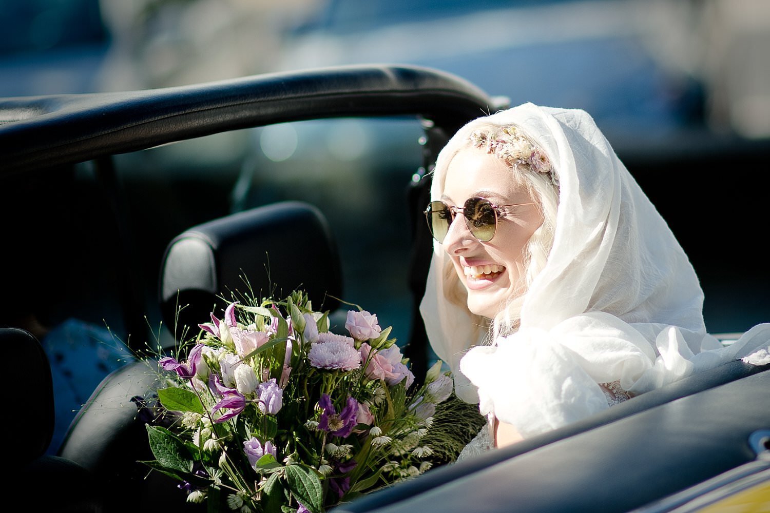 Braut winkt aus Wagen