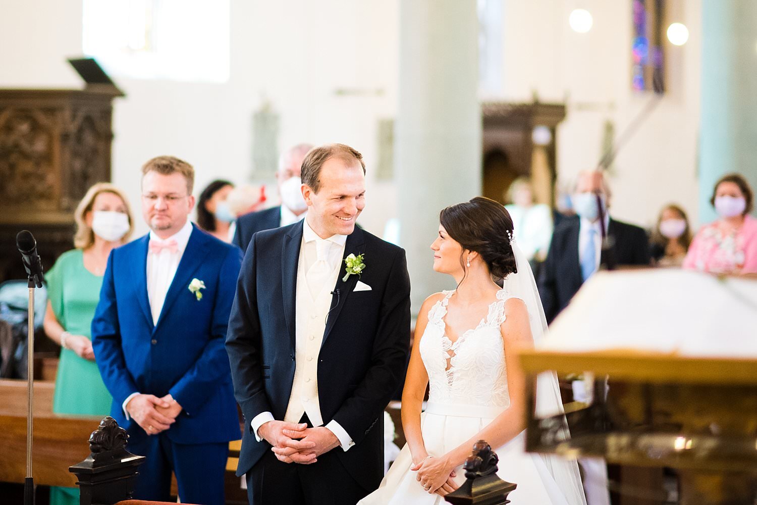 Braut und Bräutigam lächeln sich an beim Altar