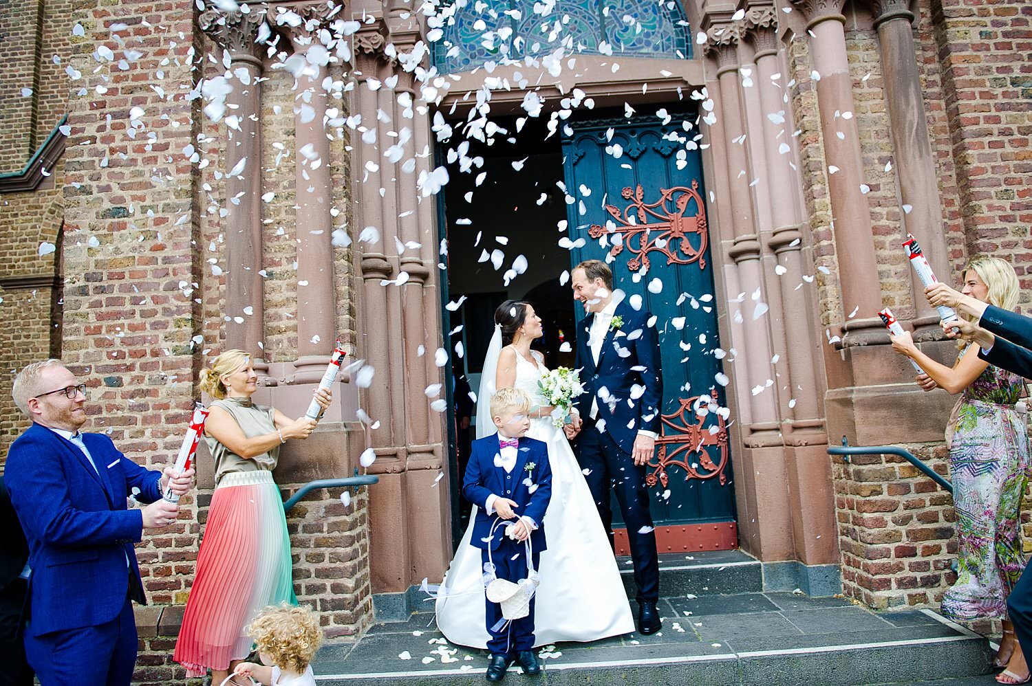 Braut und Bräutigam stehen im Eingang der Kirche