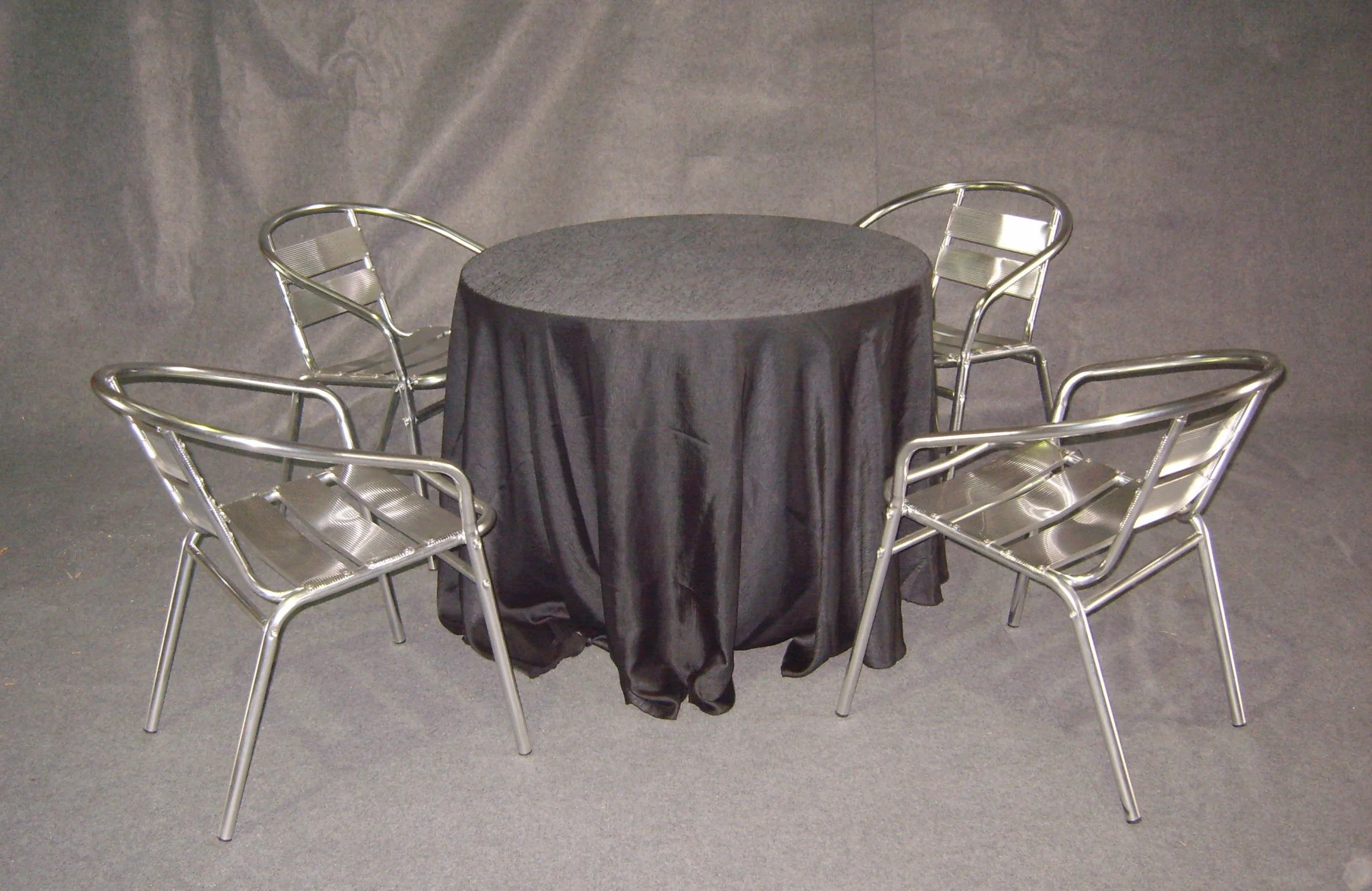 Coffee table w/ black table cloth and aluminium chairs
