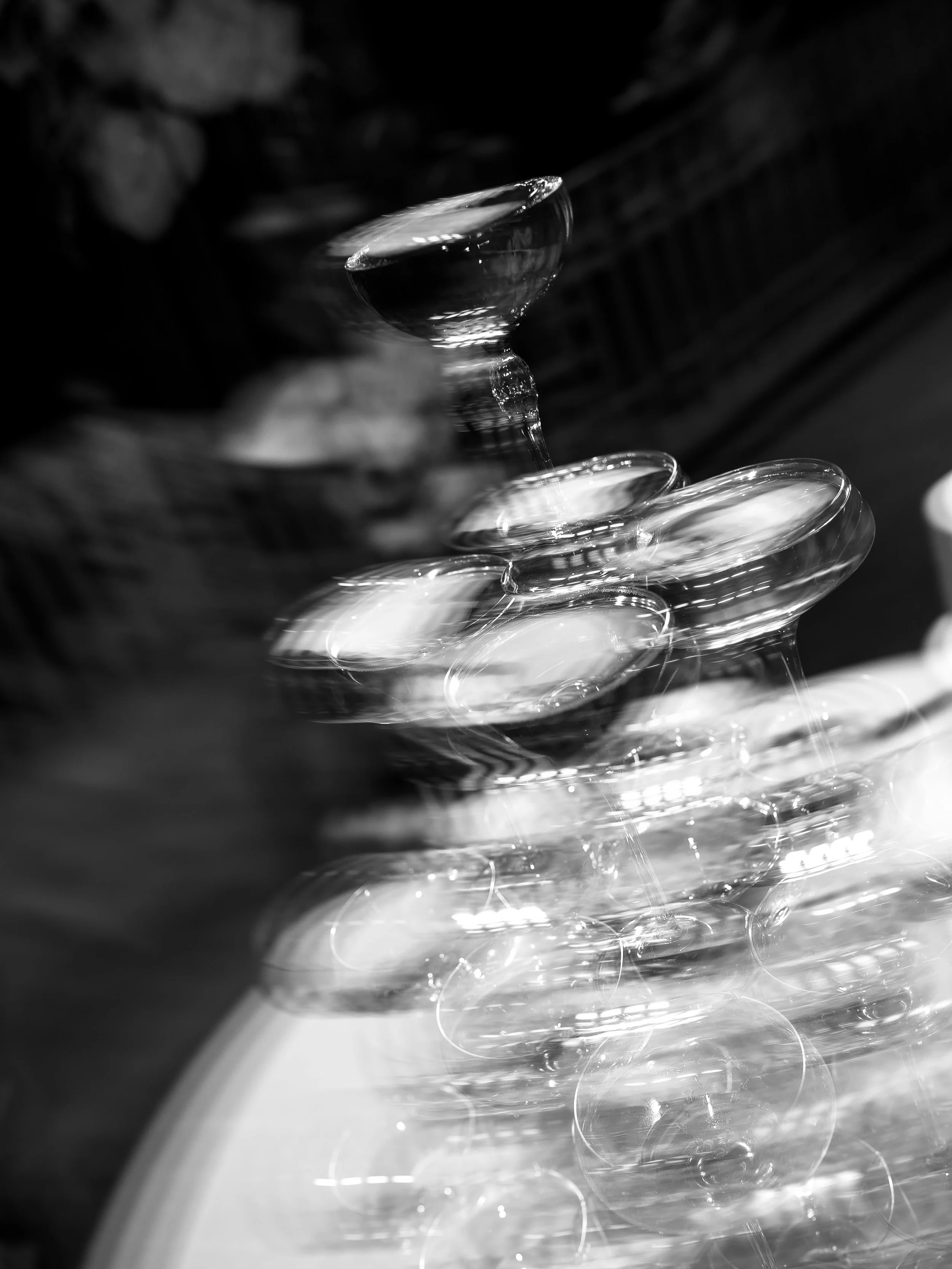 Stack of empty coupe glasses on a round table, blurred background.