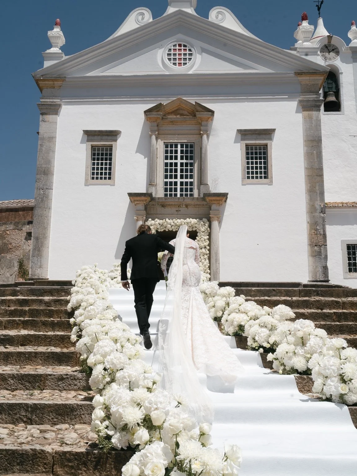 Perrie and Alex leaving the church through white flowers