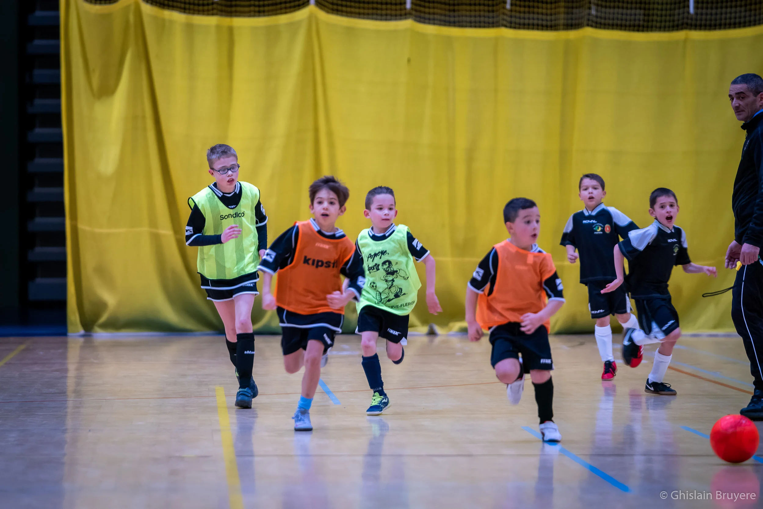 Match de football en salle d'enfant photographié par un photogr
