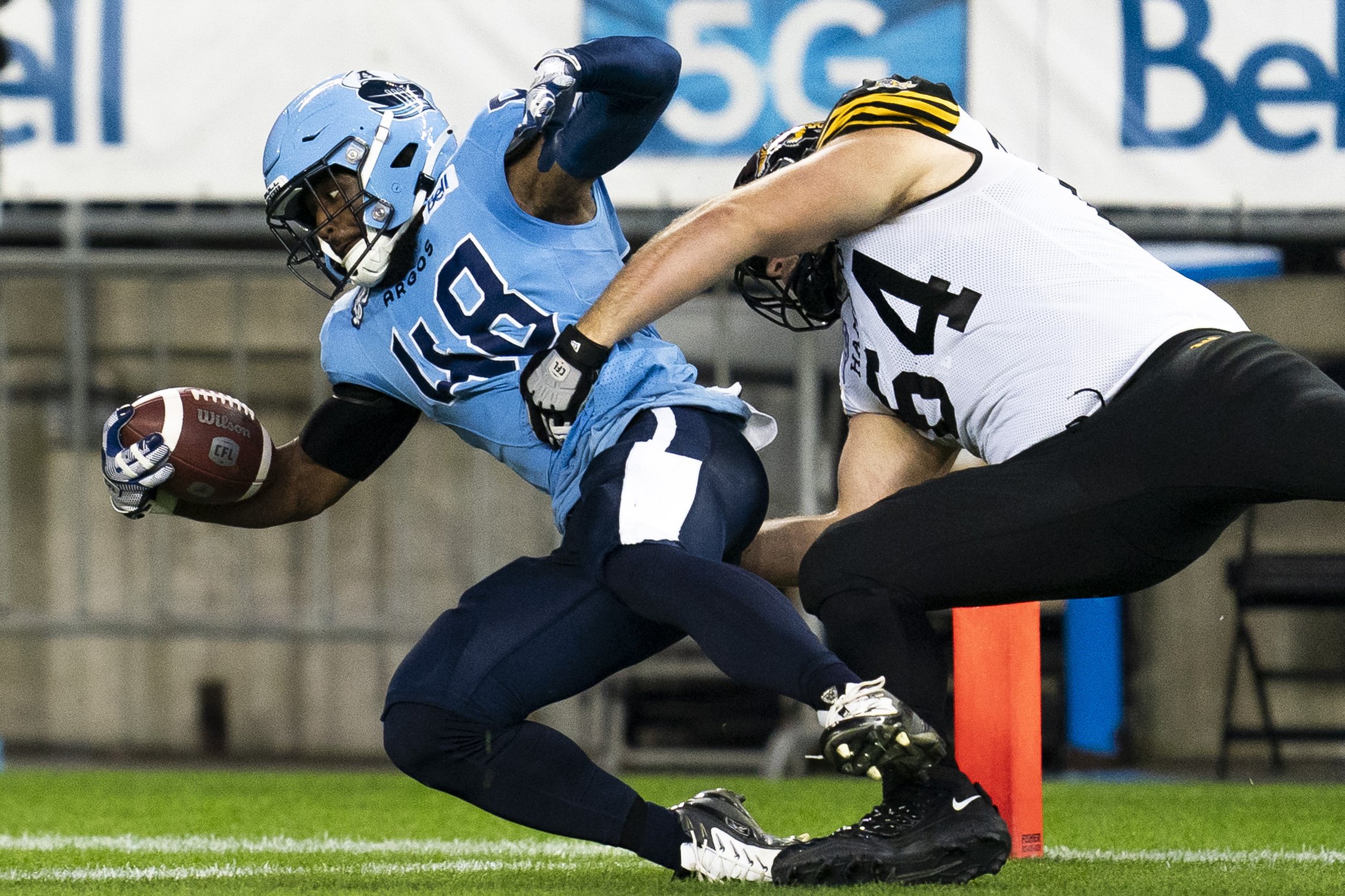  Toronto Argonauts linebacker Wynton McManis (48) makes a touchdown as Hamilton Tiger-Cats offensive linemen Coulter Woodmansey (64) attempts a tackle during first half CFL football action in Toronto, on Saturday, Sept. 23, 2023. THE CANADIAN PRESS/S