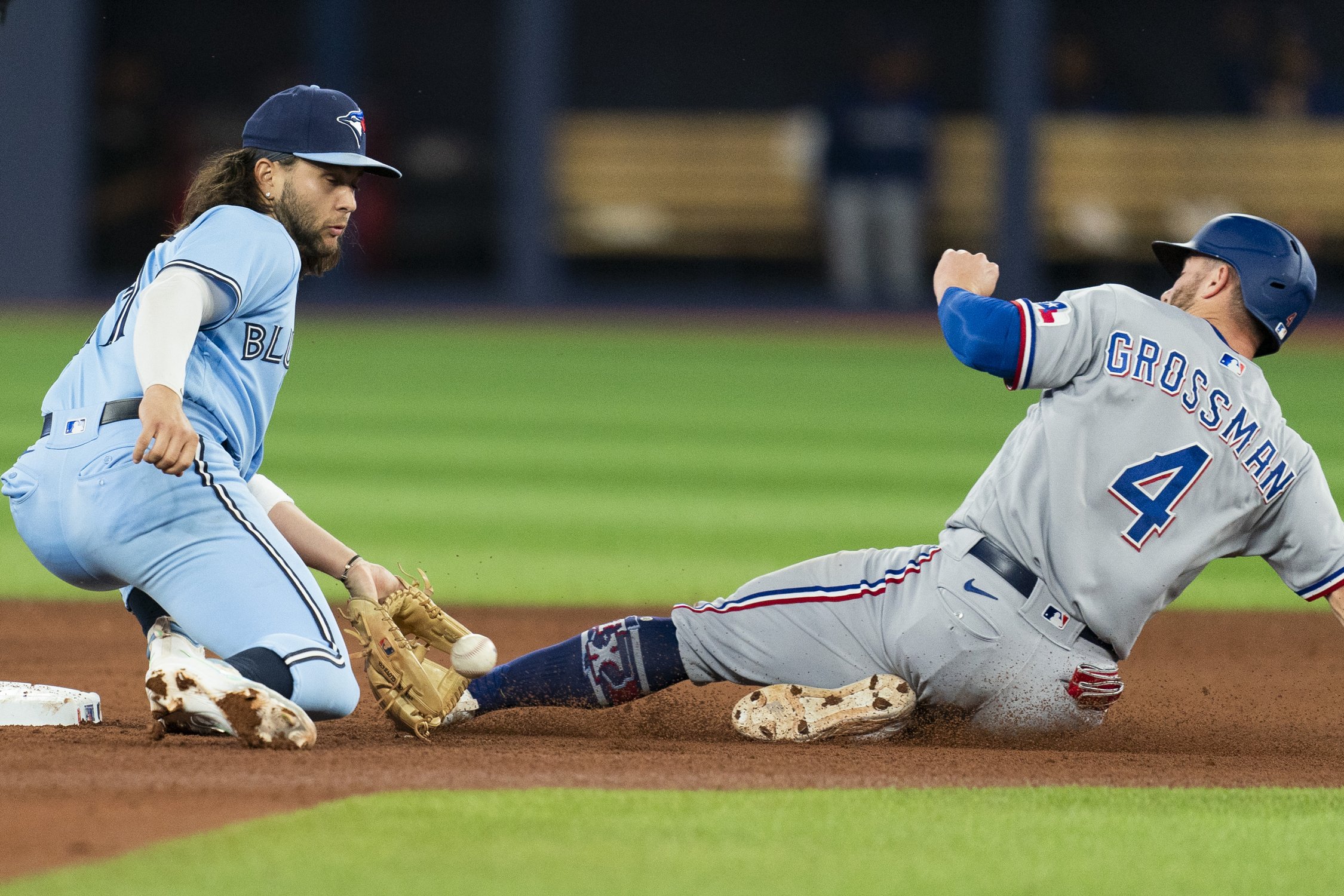 Texas Rangers right fielder Robbie Grossman (4) is called safe as Toronto Blue Jays shortstop Bo Bichette (11) attempts a tag during fifth inning American League MLB baseball action in Toronto, on Thursday, Sept. 14, 2023. THE CANADIAN PRESS/Spencer