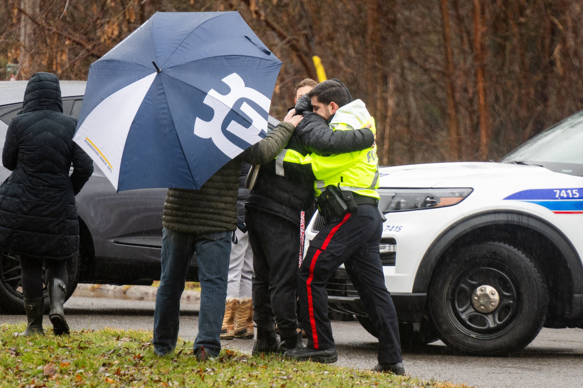  An officer from the Ottawa Police Service (OPS), right, hugs a person believed to be an immediate family member of one of four teenagers who fell through the ice near Nicholls Island Rd. in Ottawa's Manotick region, on Thursday, Dec. 28, 2023. THE C