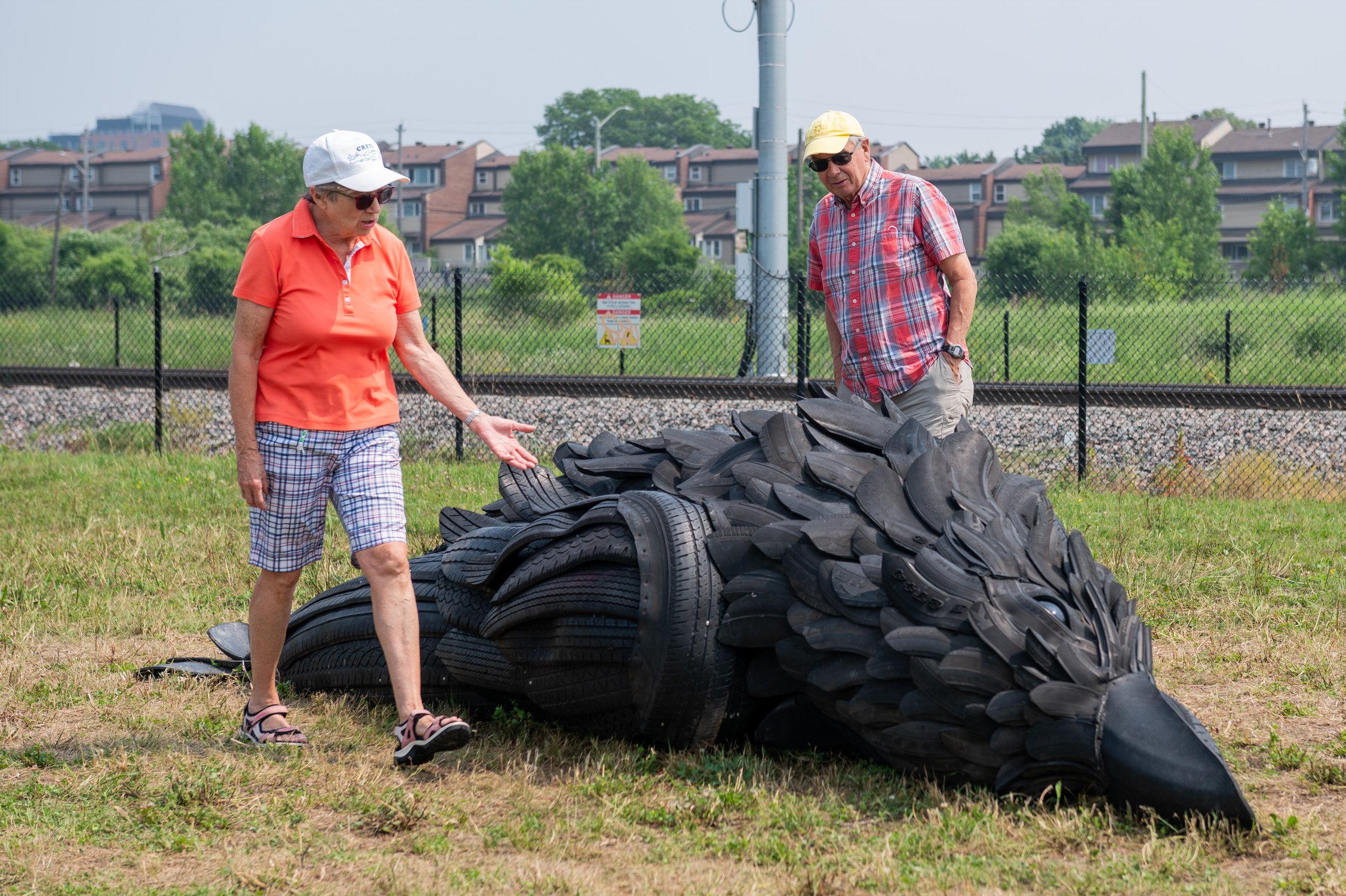  Ottawa residents Mary Ann Guy, left, and Vaughn Guy, take in an art installation depicting a crow made from the rubber material of tires is seen along the LeBreton Flats Pathway in Ottawa, on Thursday, June 29, 2023. The new installation titiled, 'W