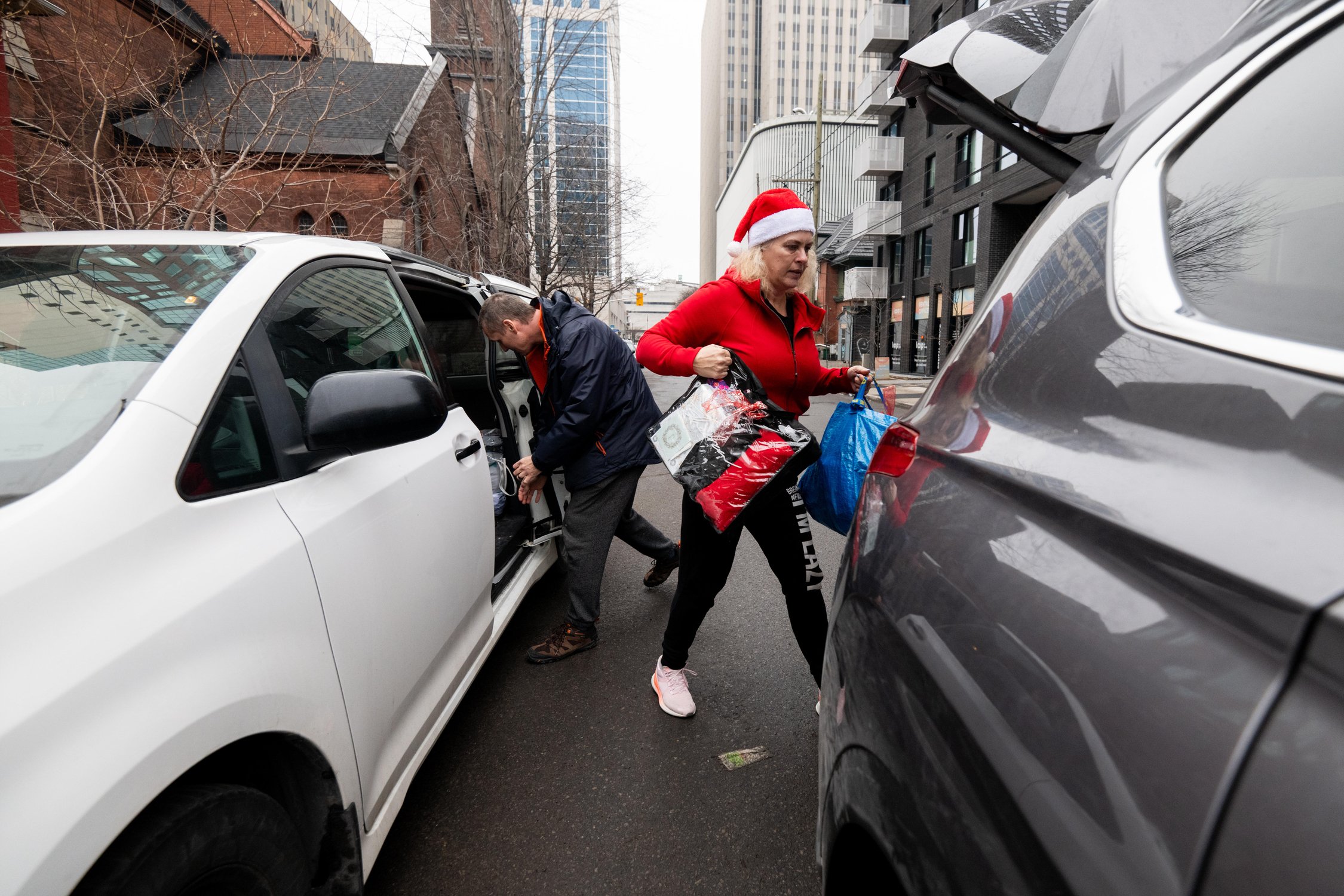  Patrick Burnside, left, husband to Shawna Thibodeau of Shawna’s Outreach helps Thibodeau reload their car with gift baskets to be handed out to people in need on Christmas Day in Ottawa on Monday, Dec. 25, 2023. THE CANADIAN PRESS/Spencer Colby 