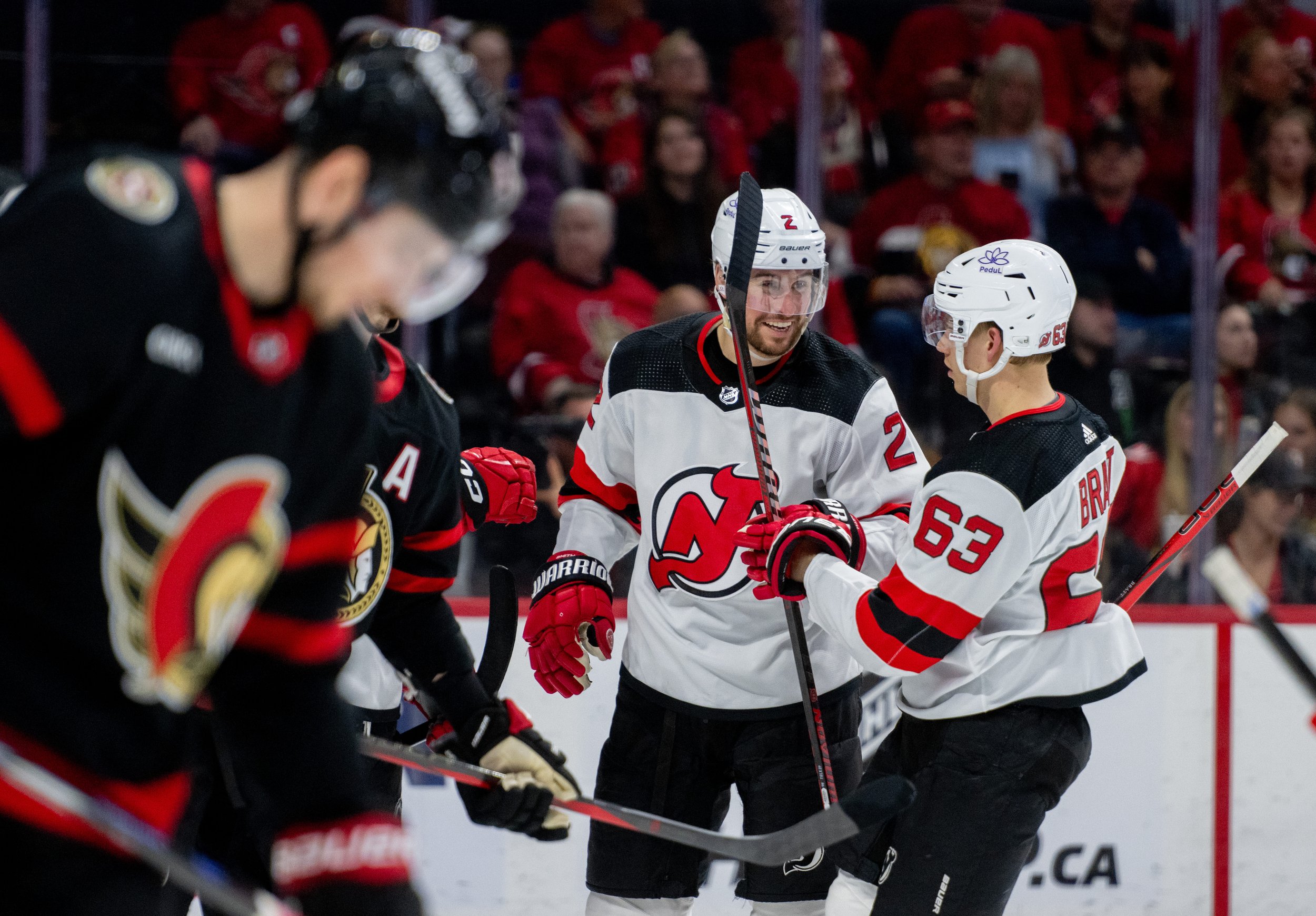  New Jersey Devils defenceman Brendan Smith (2) and left wing Jesper Bratt (63) celebrate a goal scored by  centre Nico Hischier, not pictured, against the Ottawa Senators during the second period of NHL action in Ottawa, on Saturday, April 6, 2024. 