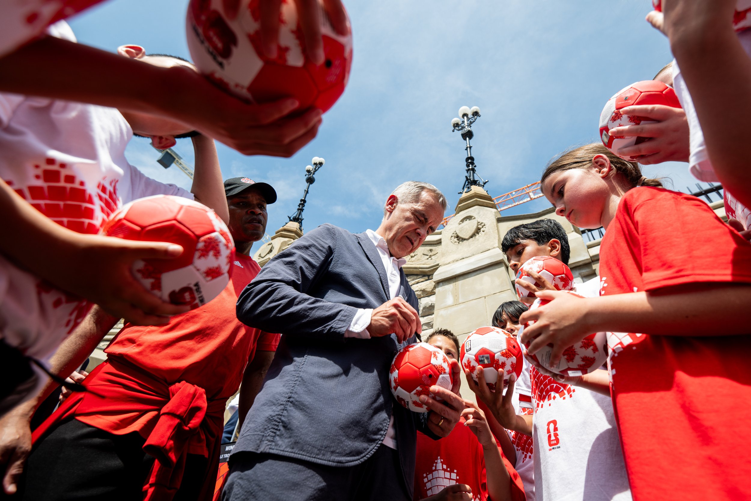  Prime Minister Mark Carney signs miniature FIFA soccer balls for youth following a soccer game on Parliament Hill marking the upcoming FIFA World Cup championships in Ottawa on Monday, June 30, 2025. THE CANADIAN PRESS/Spencer Colby 