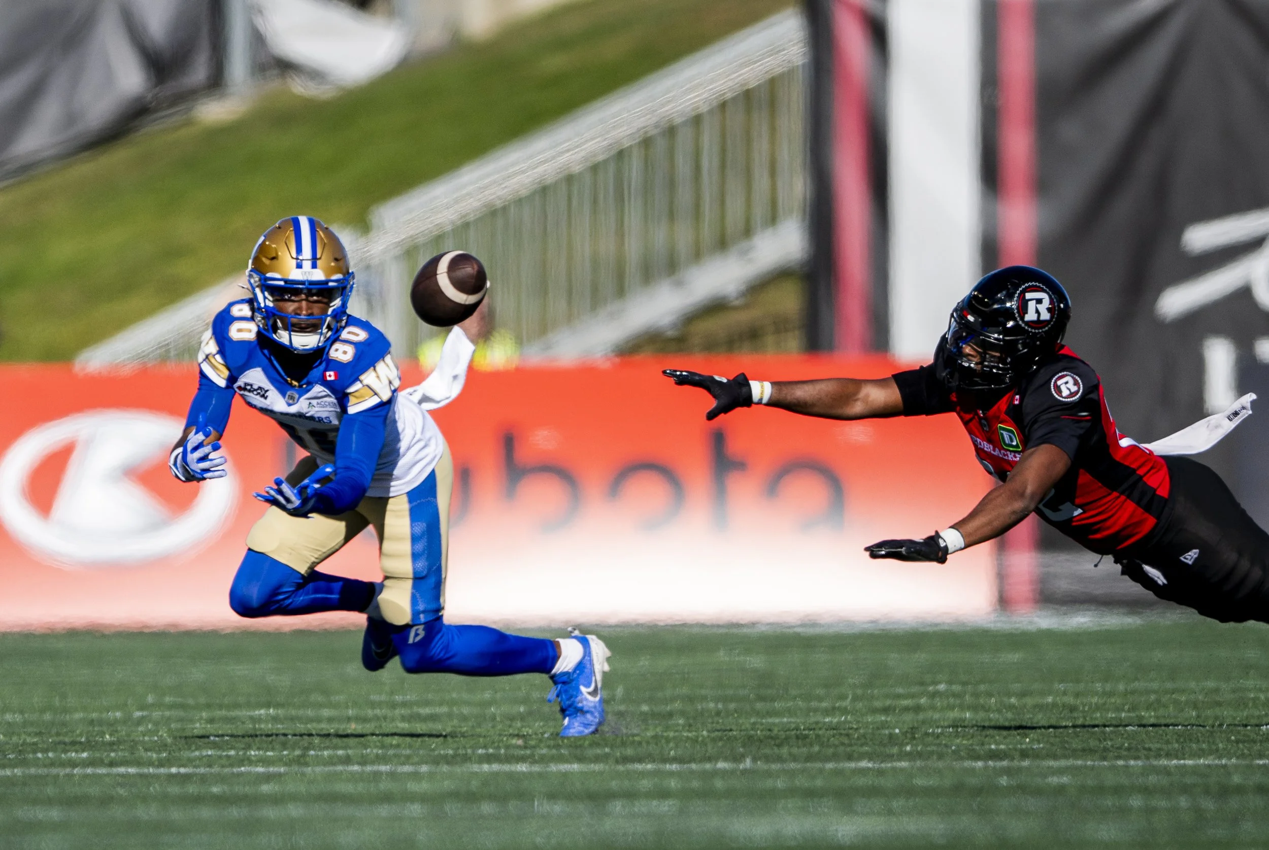  Winnipeg Blue Bombers wide receiver Ontaria Wilson (80) attempts a catch as Ottawa Redblacks defensive back Adrian Frye (22) attempts a block during first half CFL action in Ottawa, on Saturday, Sept. 20, 2025. THE CANADIAN PRESS/Spencer Colby 