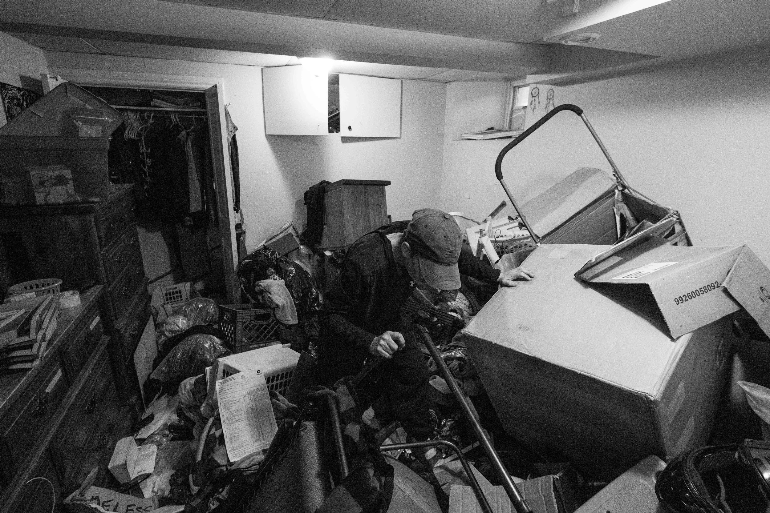  Thumper digs through her scattered belongings as she looks for sentimental items and important documents in the bedroom of her basement unit in the Glebe neighbourhood 