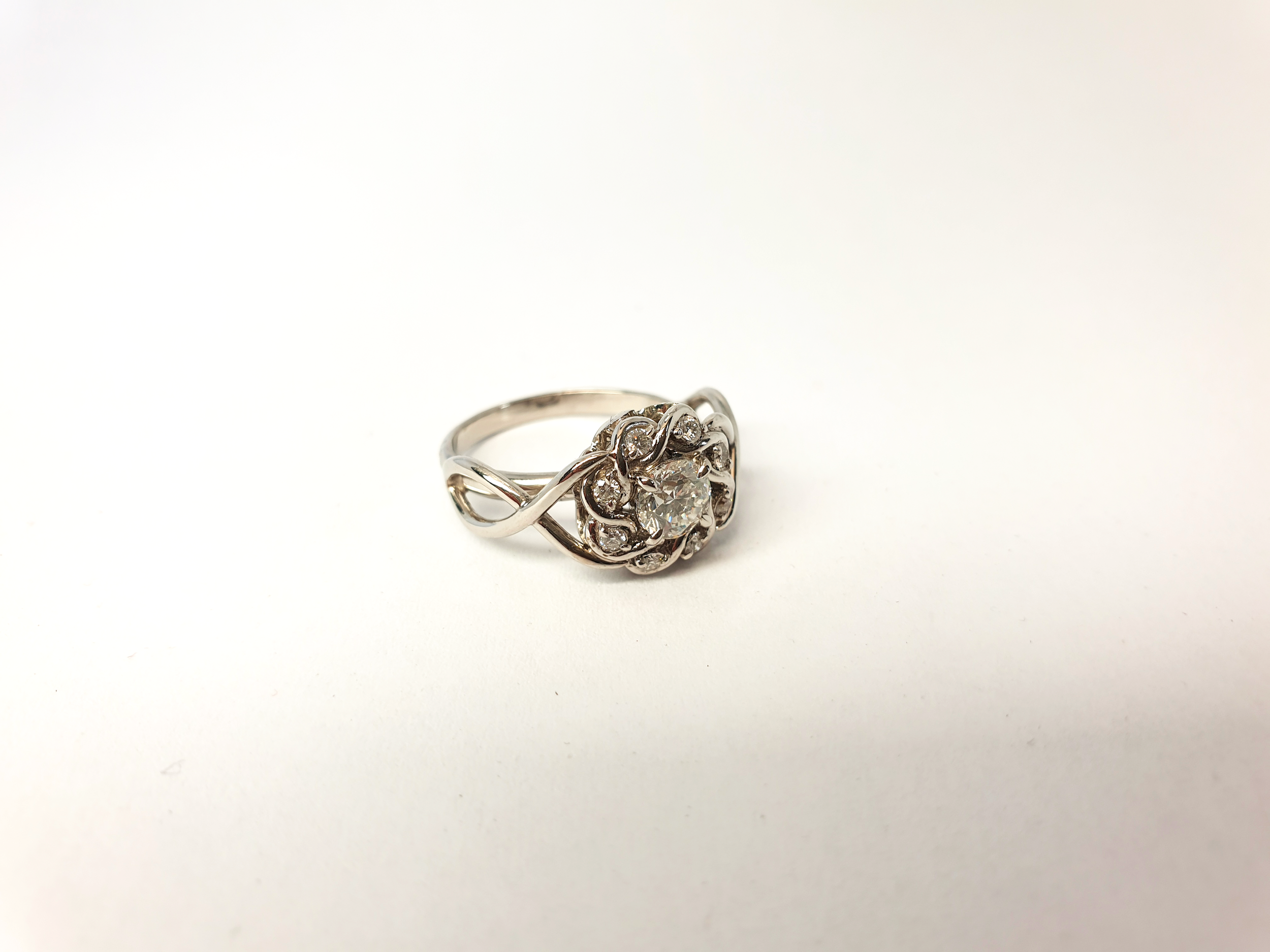 Bague de fiançailles type entourage / entrelacs en platine et diamants.