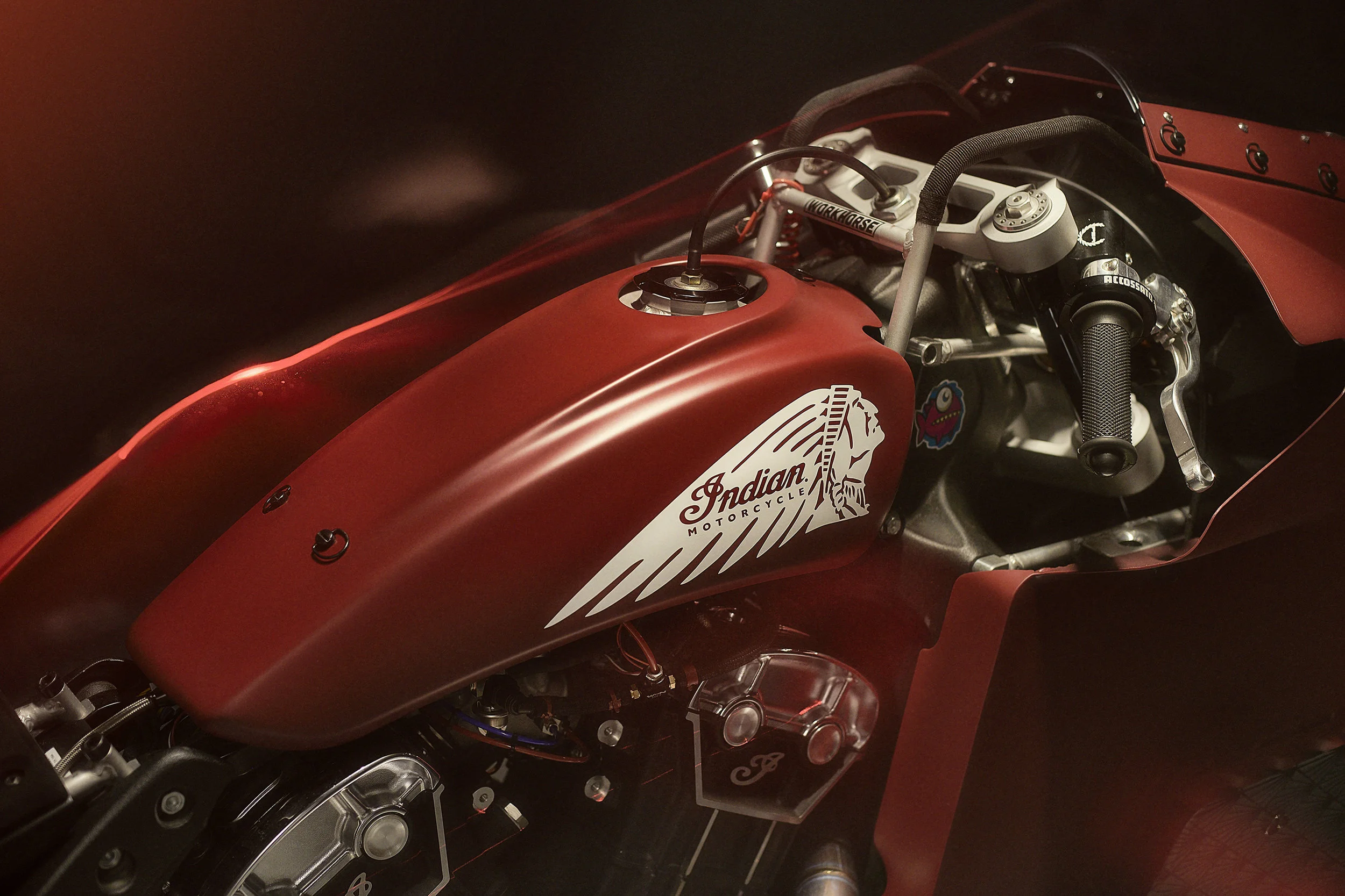 Close-up of a red Indian Motorcycle racing motorcycle with visible engine parts and handlebars.