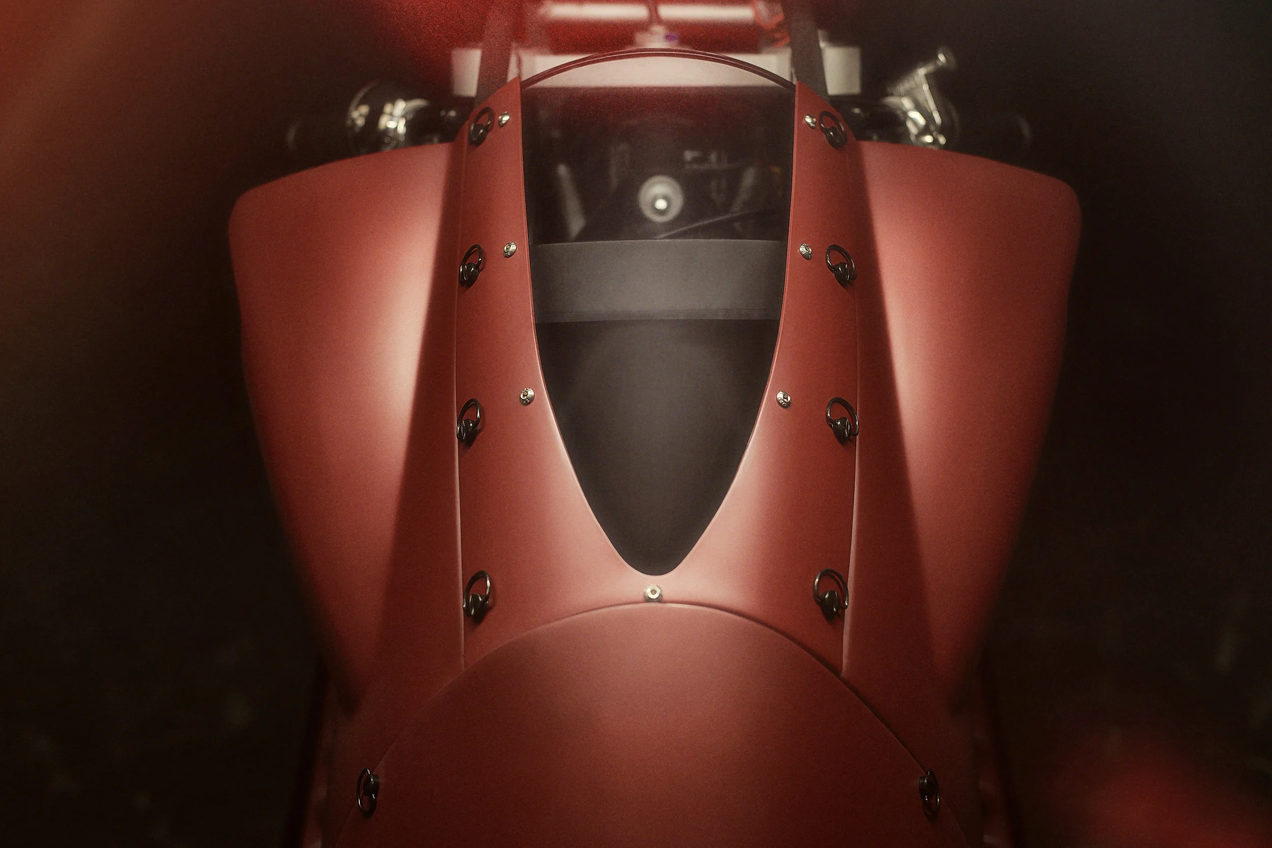 Front view of a red race car with a sleek aerodynamic design and a black cockpit window.