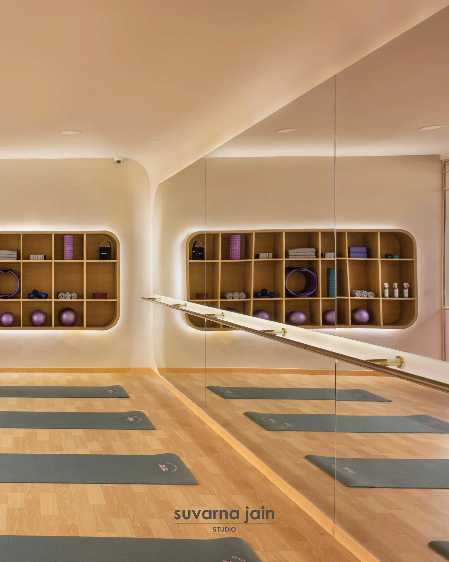 inviting movement; the yoga studio is shaped as a quiet, expansive volume, where softened surfaces, muted tones, and controlled light allow breath to settle before motion begins 

the calm carries forward into the adjoining corridor, where gentle tra