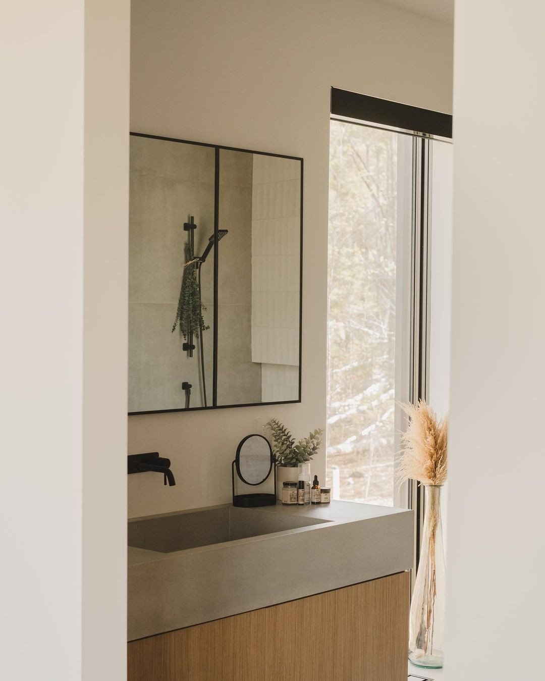 This bathroom exudes serenity with its neutral tones and black finishes.⁠
⁠
Looking to add a natural element to your bathroom project? Add a concrete sink for the perfect blend of natural and contemporary.⁠
⁠
Inquire today about our selection of conc