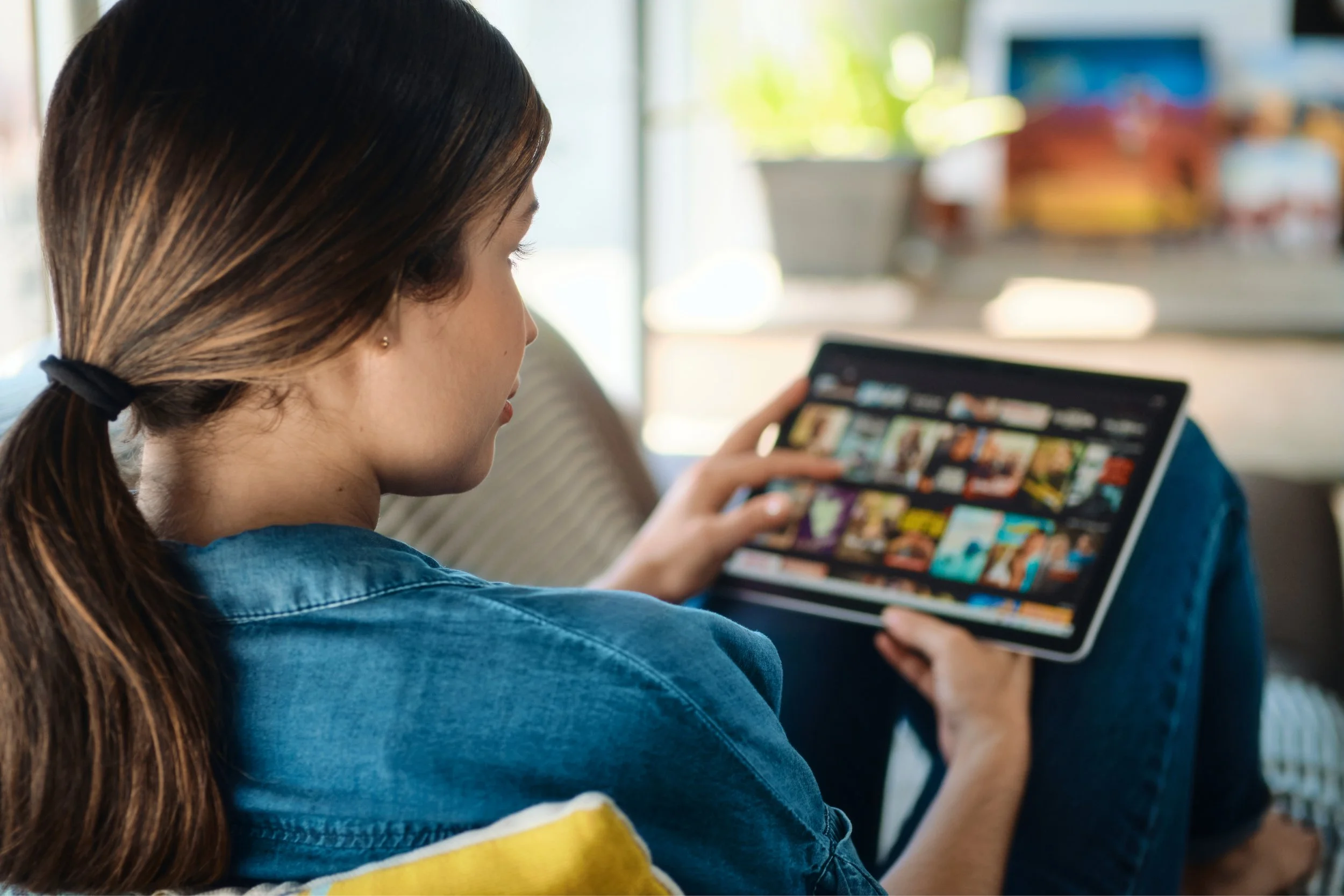 woman-choosing-movie-for-streaming-on-tablet-2021-08-29-10-21-14-utc.jpg
