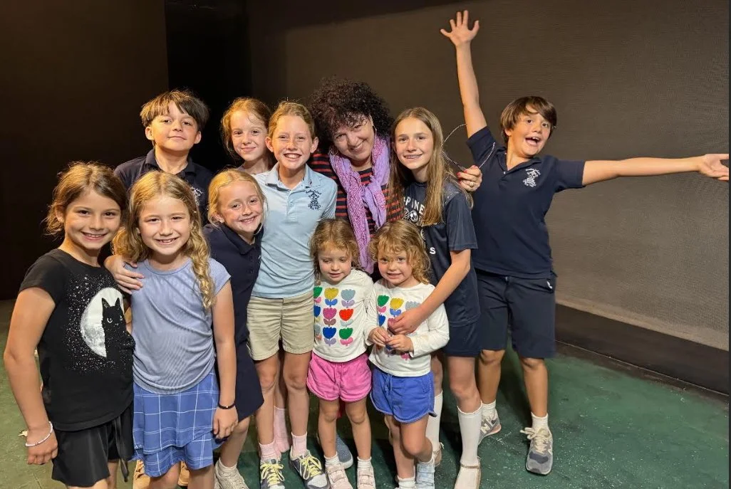 group of children smiling and huddled together and some children will silly expressive poses